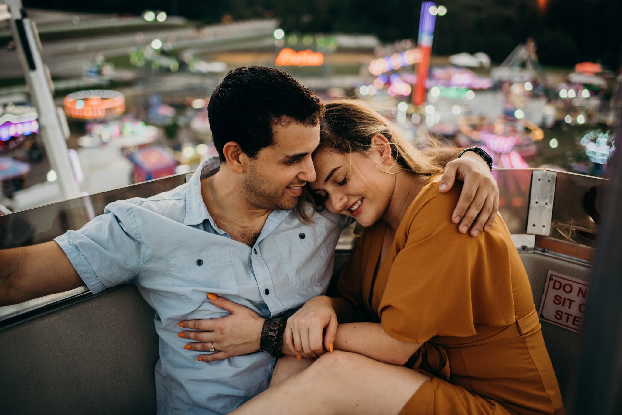 couple cuddles atop the ferris wheel at the Virginia State Fair