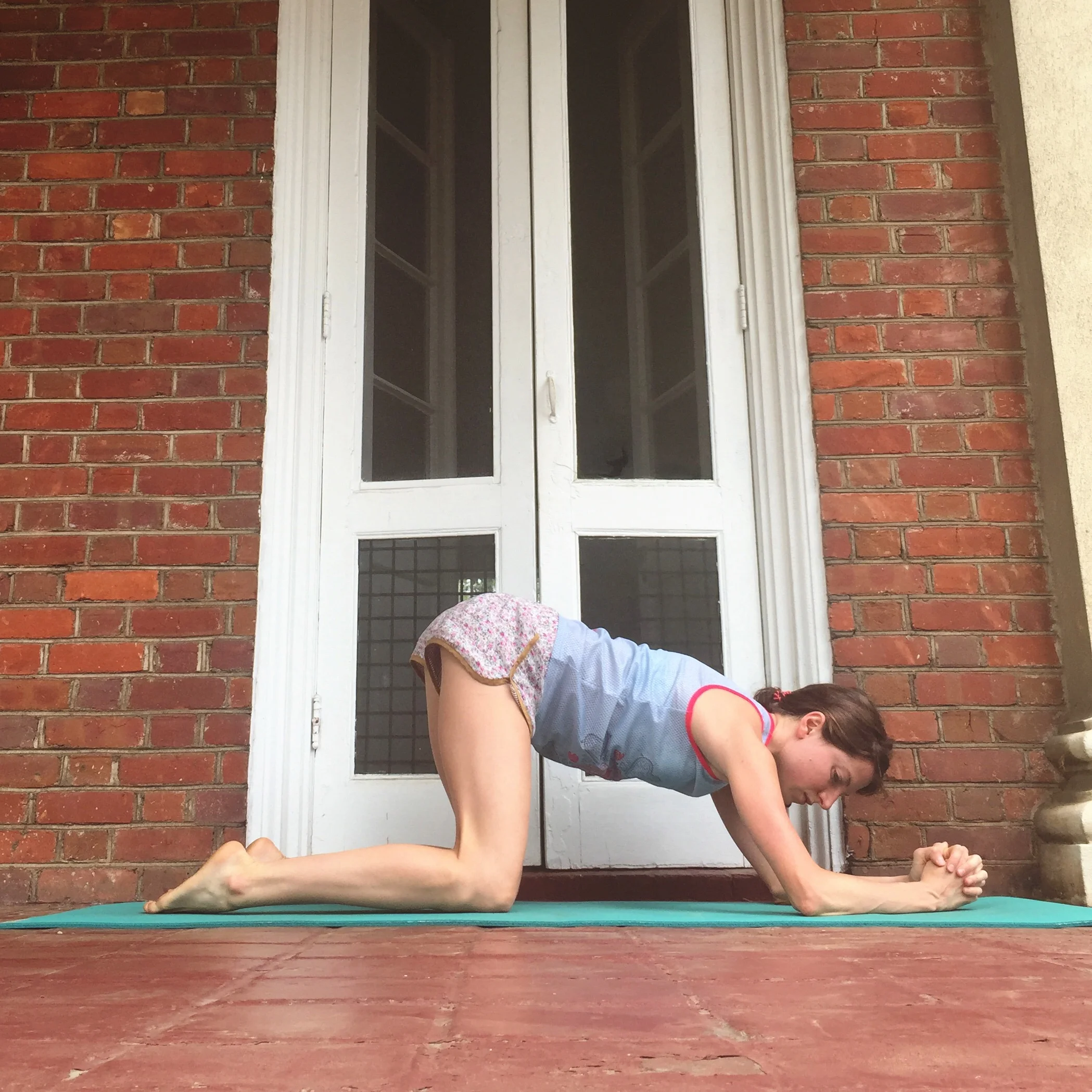   2. FOREARM CIRCLES.    From child's pose, keep your forehead on the mat while you clasp your palms in front of you. Keeping palms clasped, roll yourself up to forearms and knees. Tuck toes underneath to stretch the bottoms of your feet while you're