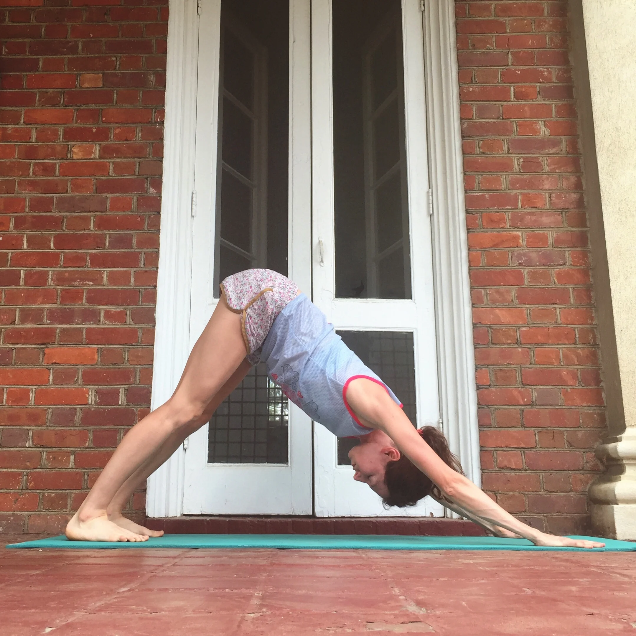   4. DOWNDOG    From child's pose, release hands to regular position shoulder-width apart at front of mat. Wiggle knees to hip-width, tuck toes under, and press into heels to send hips up and back into downdog. Work on pressing front of chest to fron