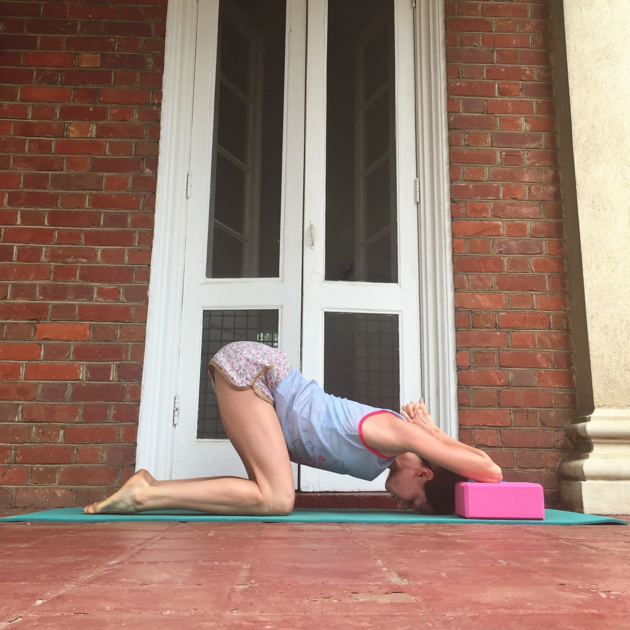   7. SHOULDER OPENER WITH BLOCKS.    Using two yoga blocks (or pillows, or books with a few blankets stacked on top), plant one elbow onto each block. Sink forehead towards the floor. Sink bum towards your heels. Stay as long as you like!  