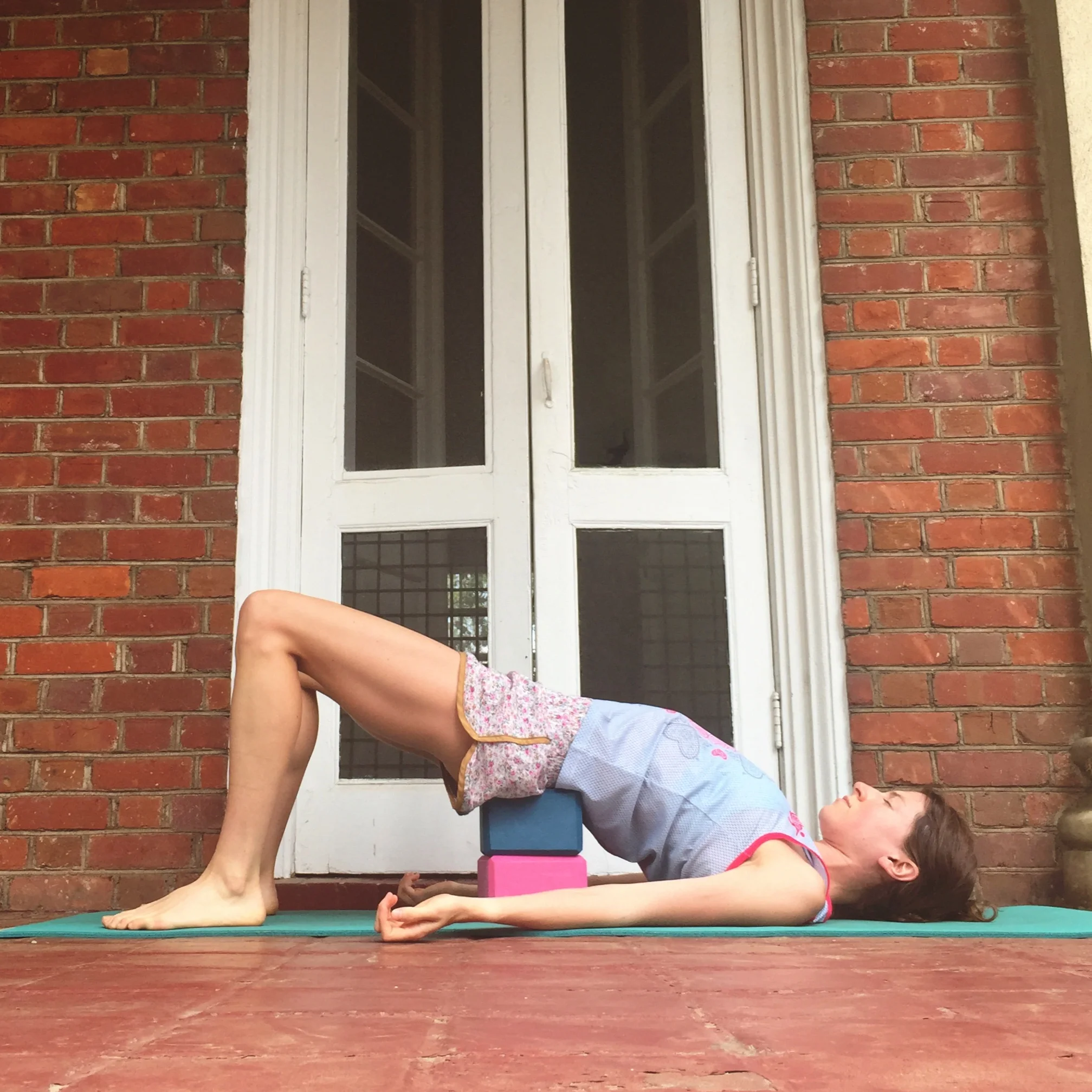   8. RESTORATIVE BACKBEND WITH BLOCK.    You may never want to get up from this one. Roll over to your back. Plant feet near your bum. Pick up hips and slide a block (or two) under your sacrum. (Tip: your sacrum is above your hips,  below  your lower