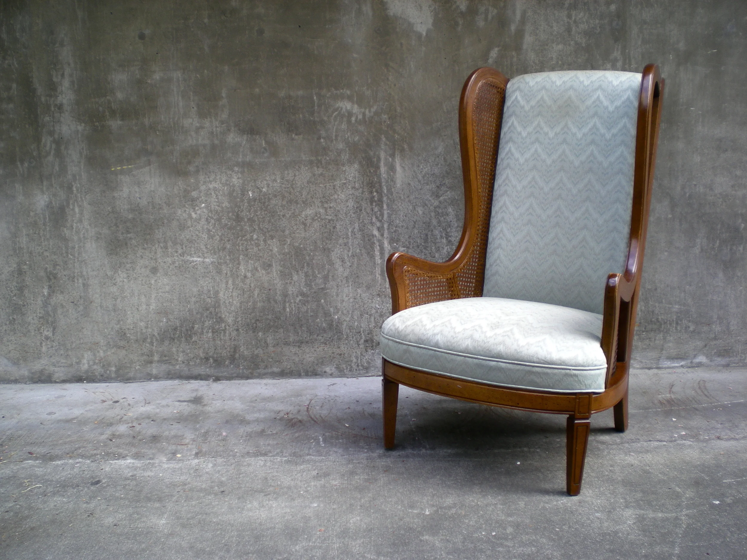 vintage cane wingback chair with chevron stripe upholstery.