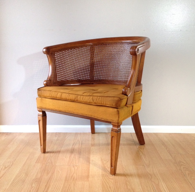 vintage cane barrel chair with gold silk upholstery.