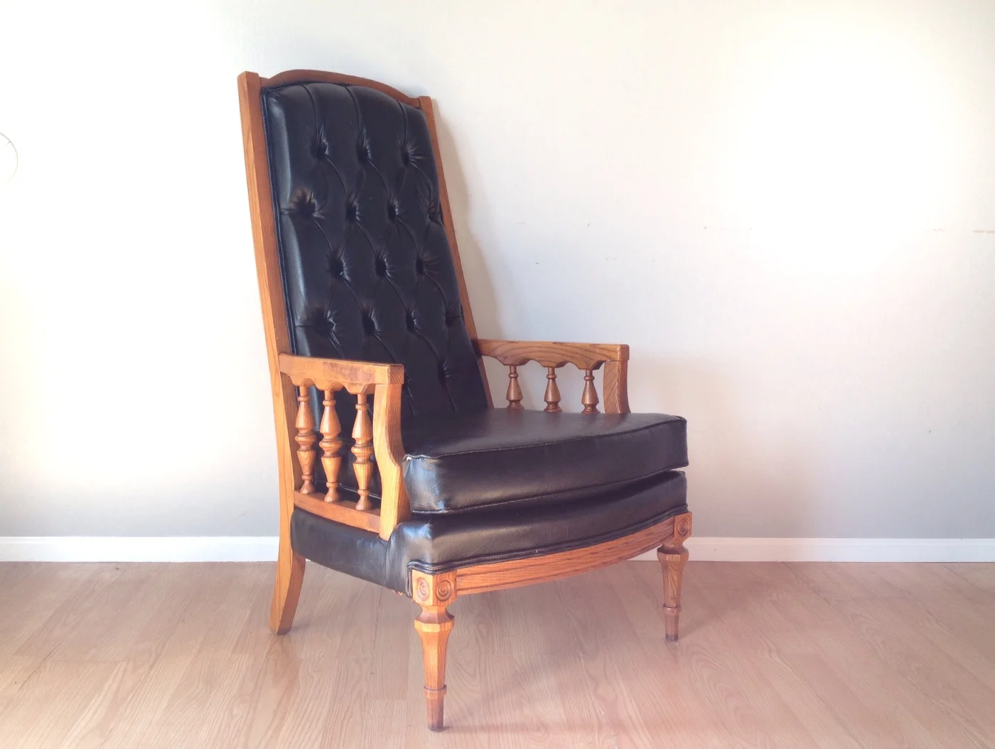vintage high back tufted black Naugahyde chair.