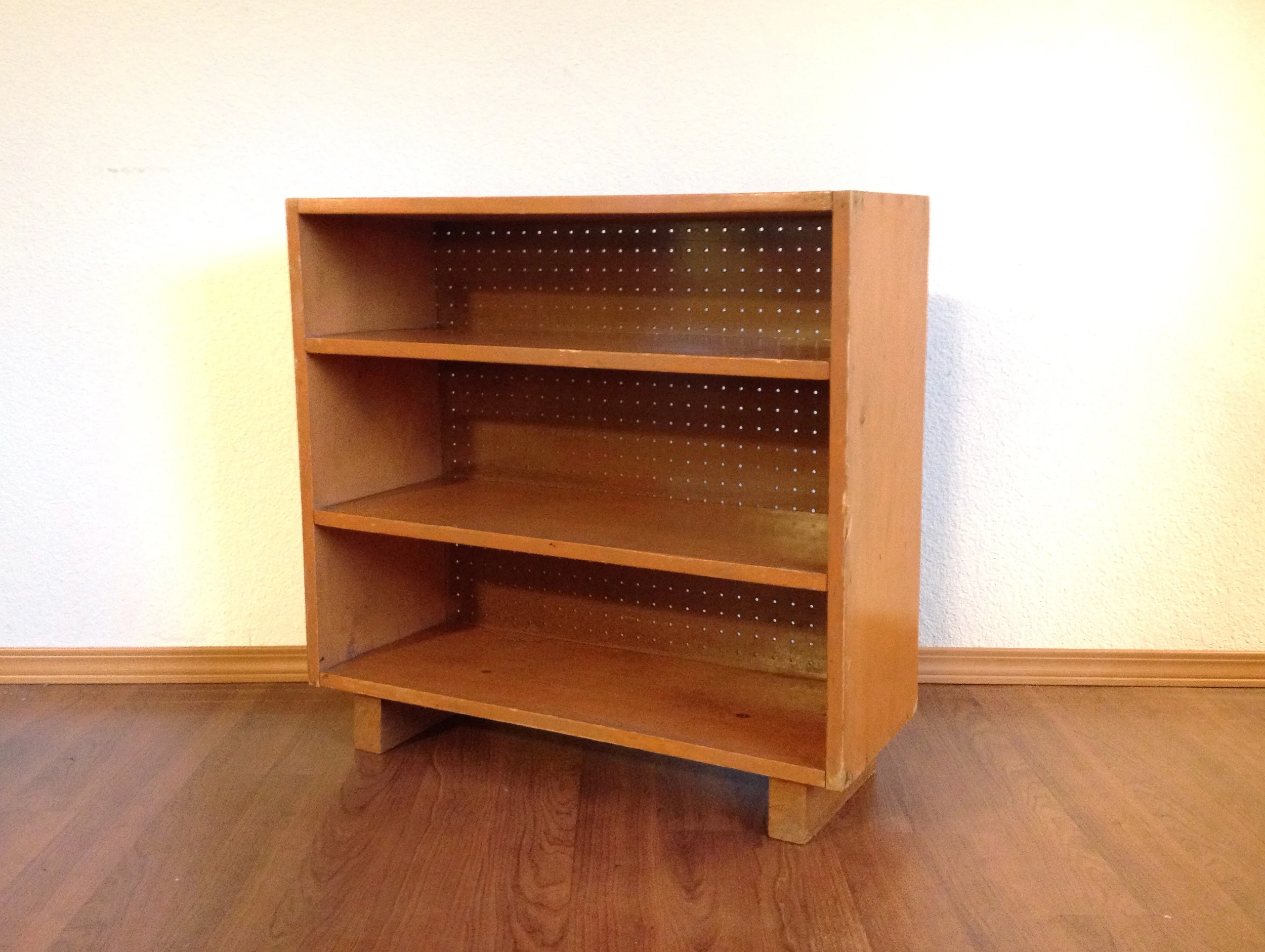 small vintage bookcase with distressed orange paint.
