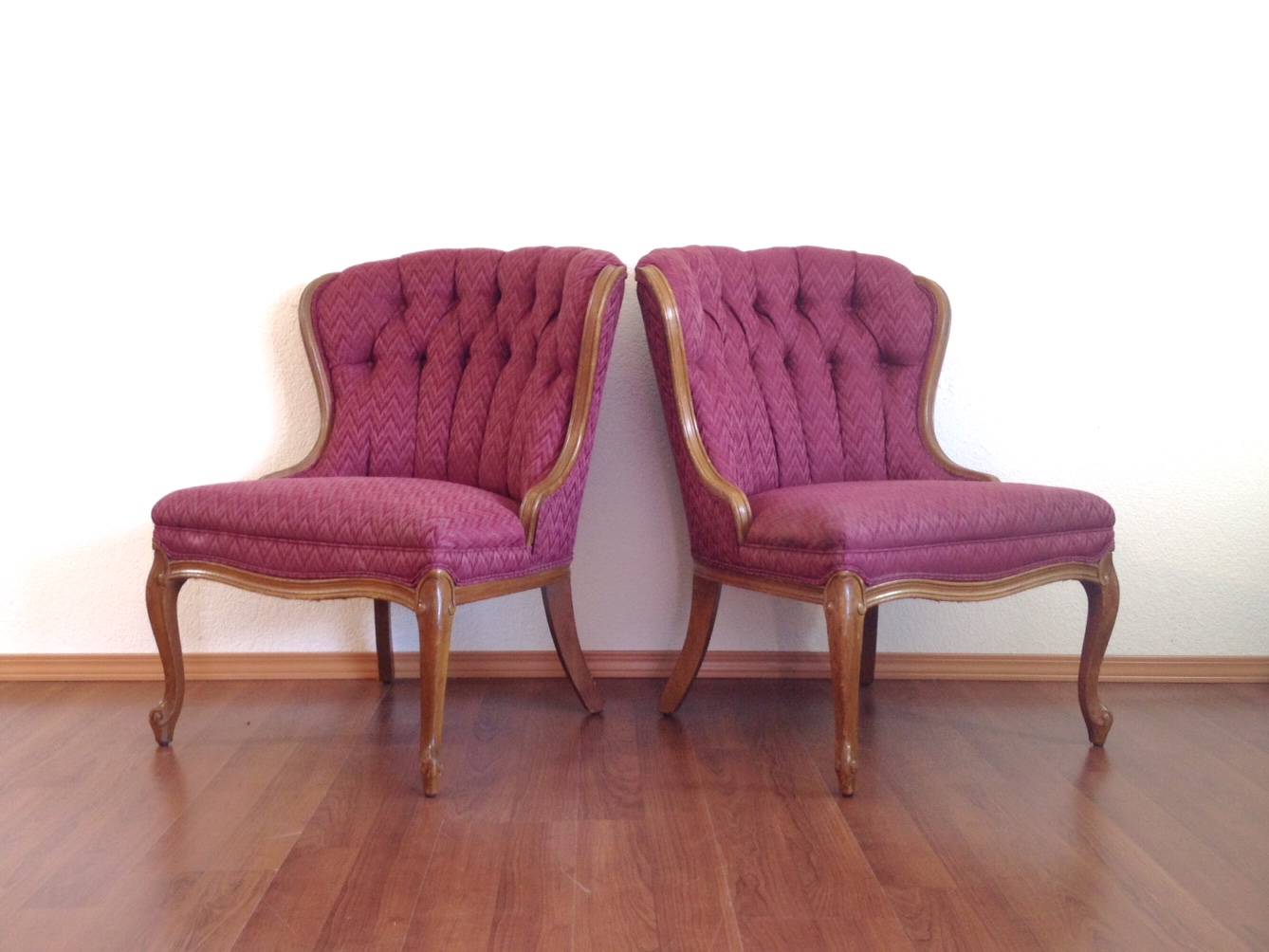 pair of vintage pink tufted slipper chairs.