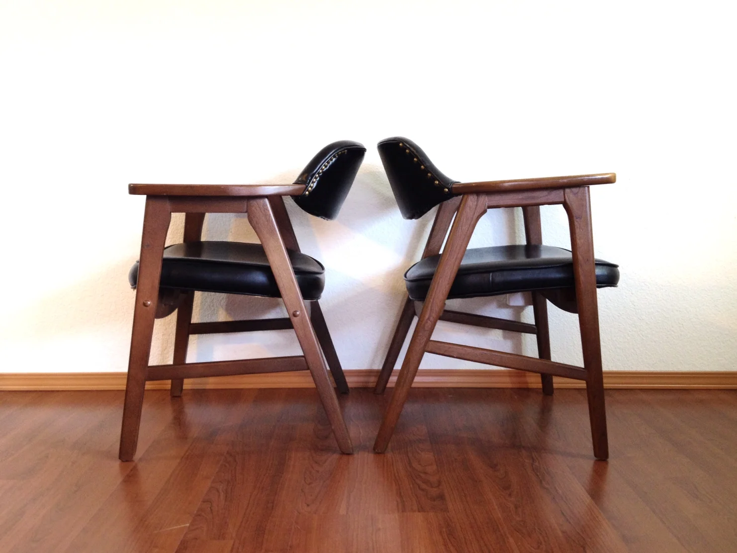 mismatch pair of black MCM chairs.