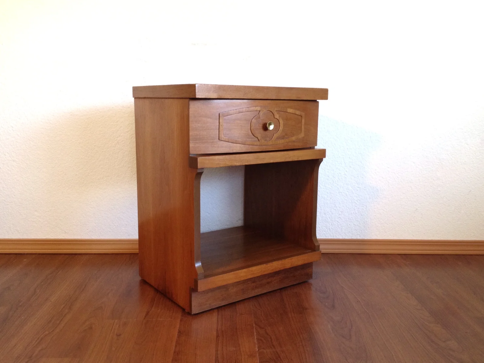vintage mid century nightstand with embellished drawer.