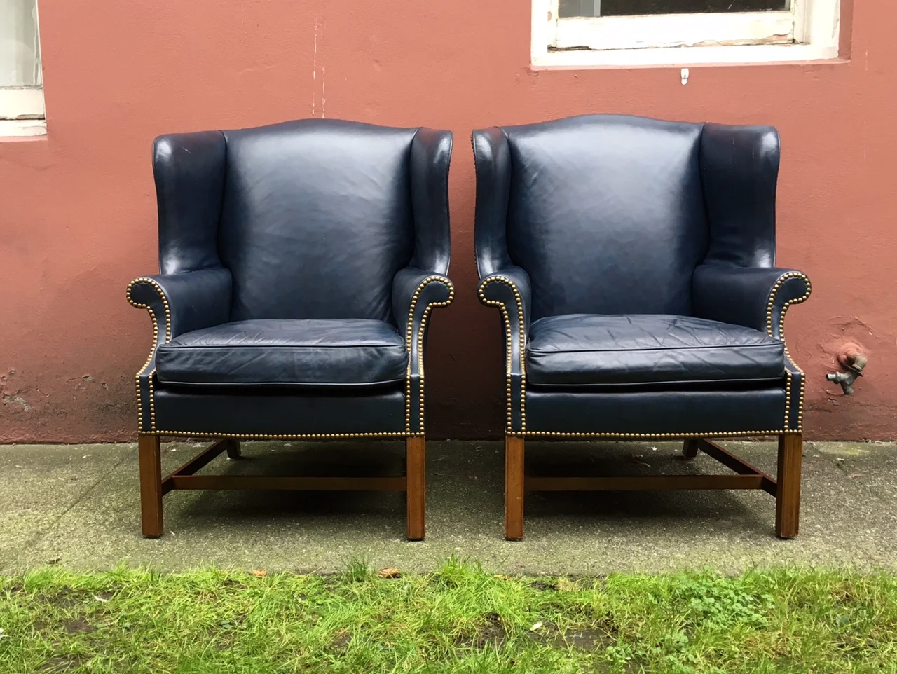 pair of vintage blue leather wingback chairs.