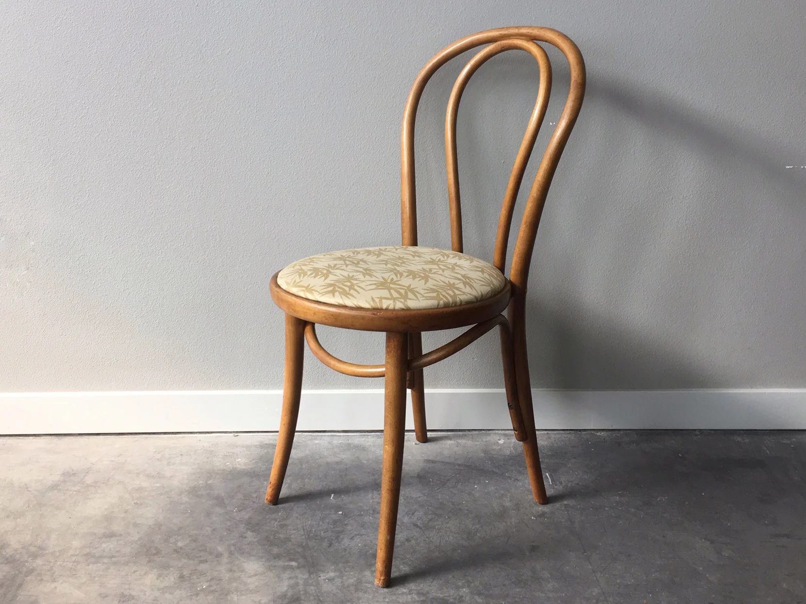 vintage mid century modern bent wood cafe chair with bamboo print upholstery.