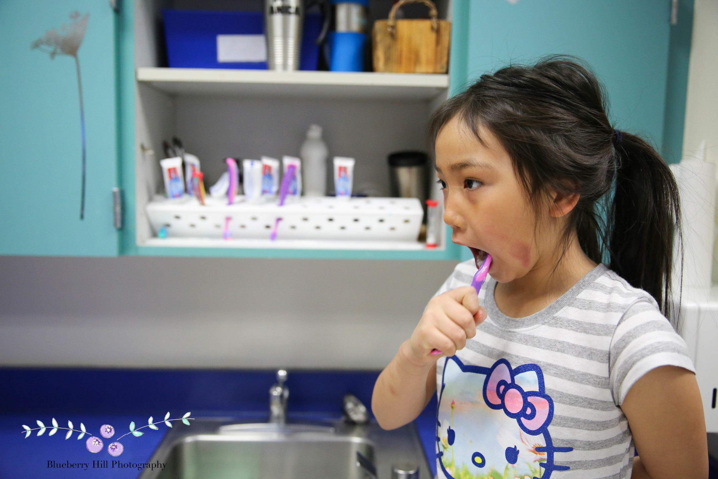 Kaylynn brushes her teeth at school. She tells me the frostbite on her cheek doesn't hurt too badly.