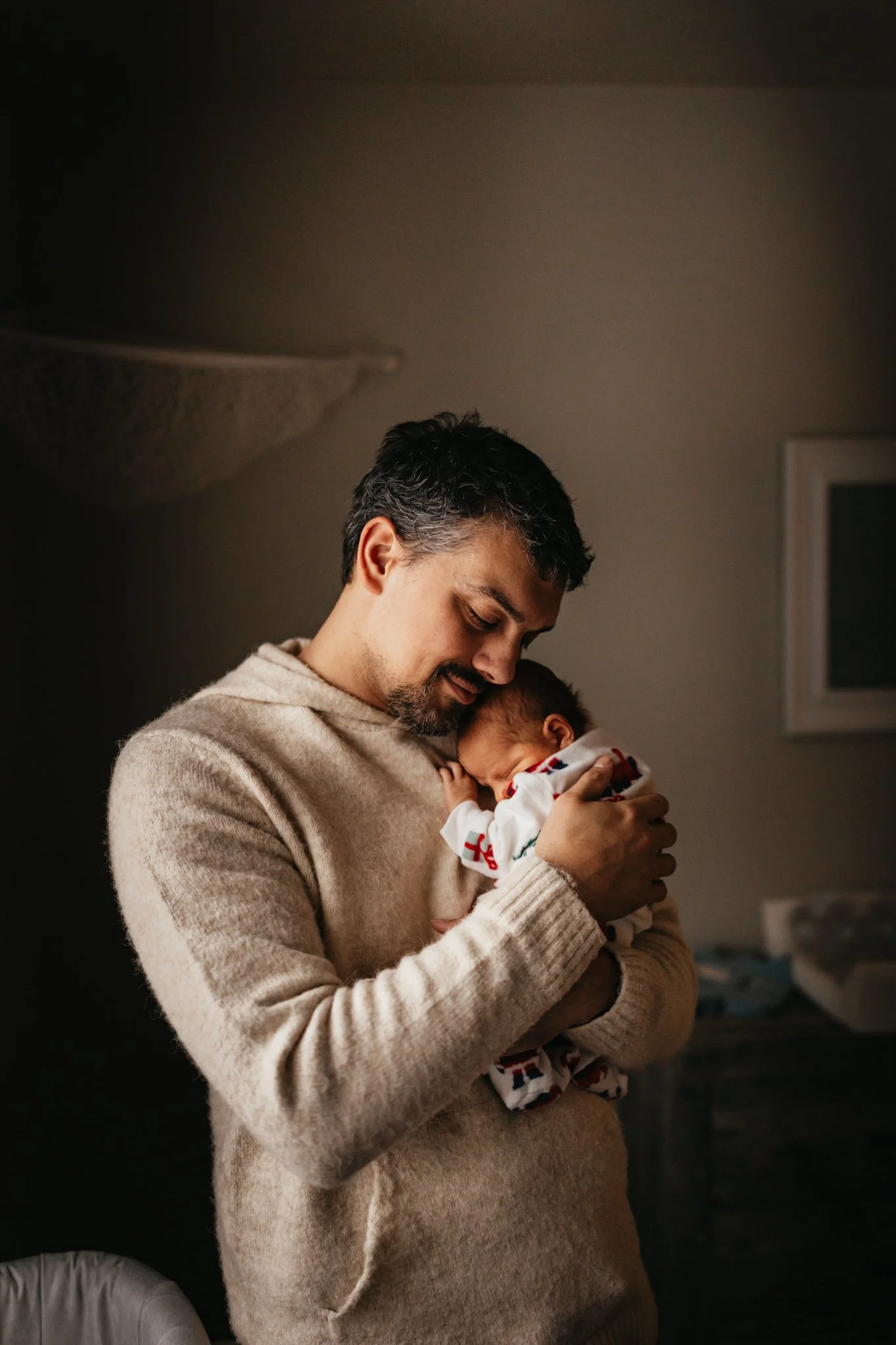 A dad snuggles a newborn baby