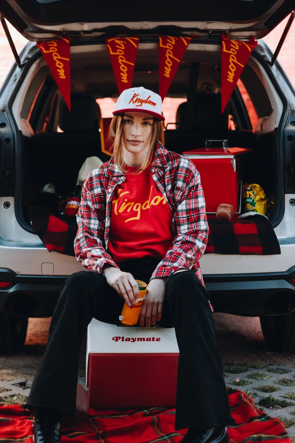 Model wearing a red Kansas City Kingdom sweatshirt in a game-day lifestyle campaign