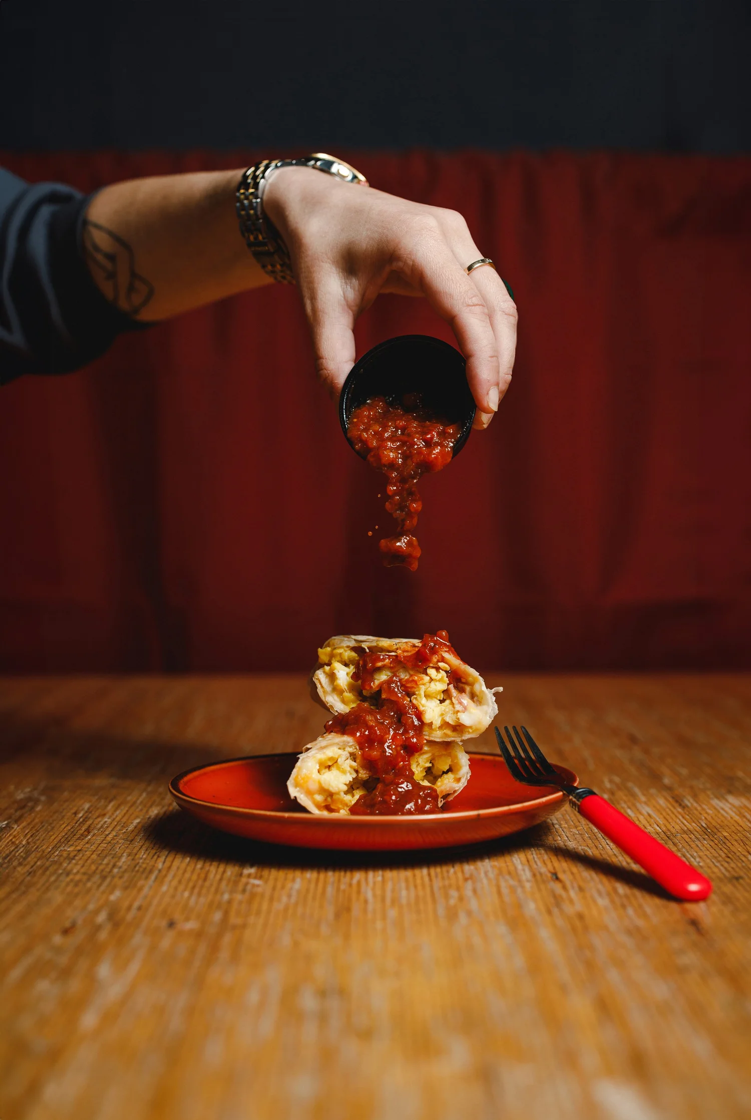 Salsa poured over a breakfast burrito