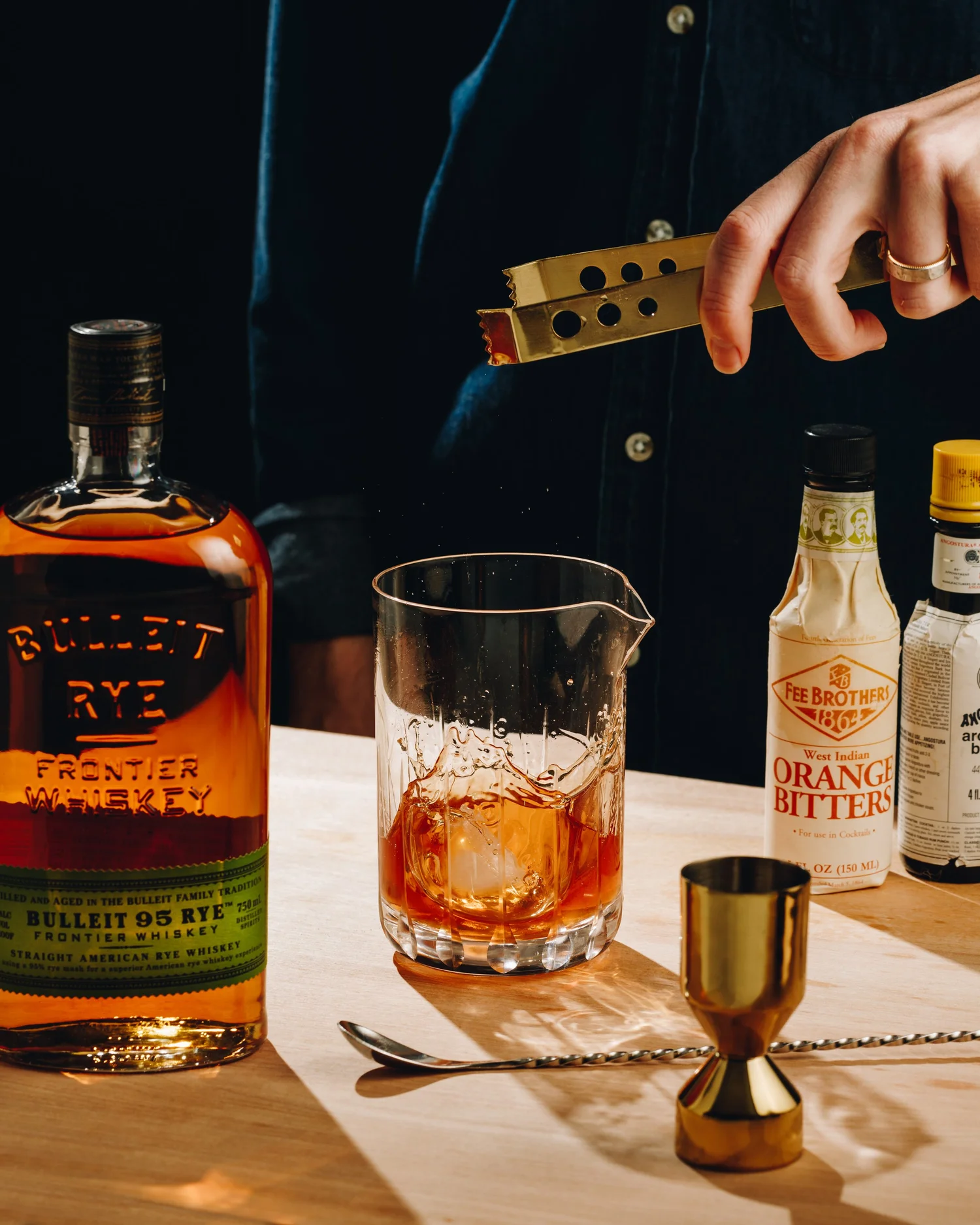 Ice and whiskey splash beside a rye bottle
