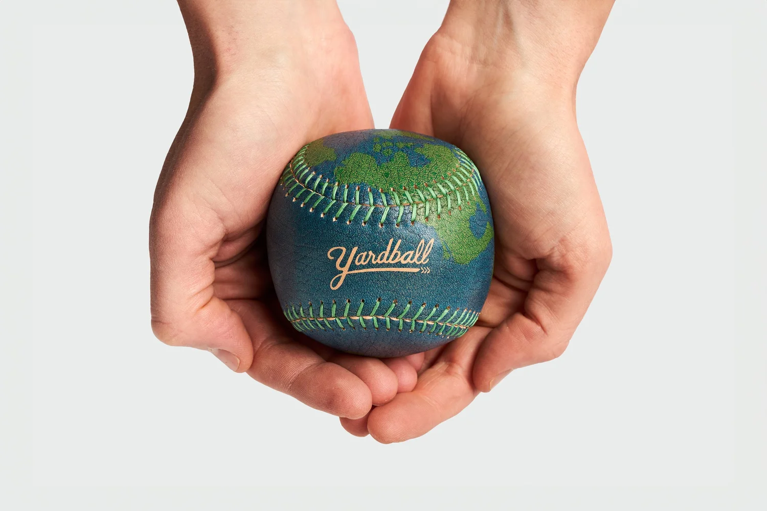 Yardball baseball held in a pair of hands