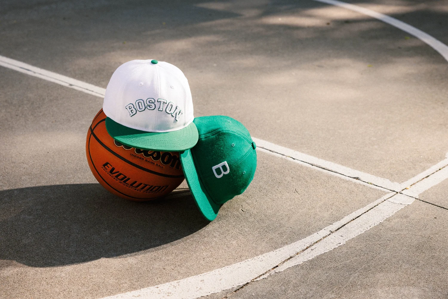 Boston basketball hats styled on a basketball court