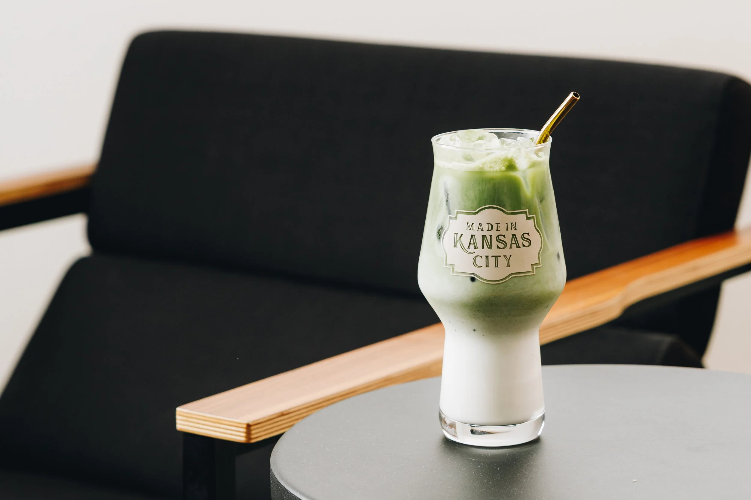 Iced matcha latte in a Made in KC glass on a cafe table - Kansas City cafe photography