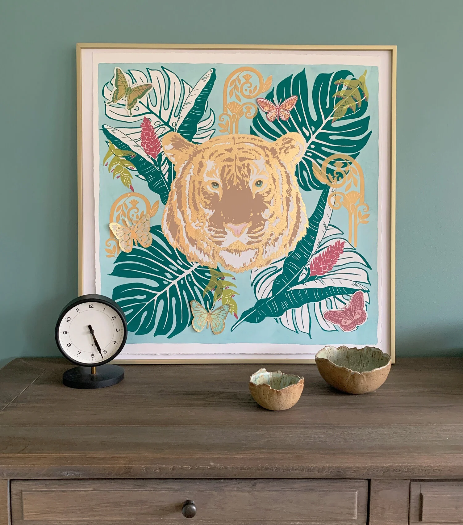 Decorative wall art featuring a tiger's face surrounded by jungle leaves, butterflies, and flowers.  Original silk screen collage by NY artist Melissa Bamber