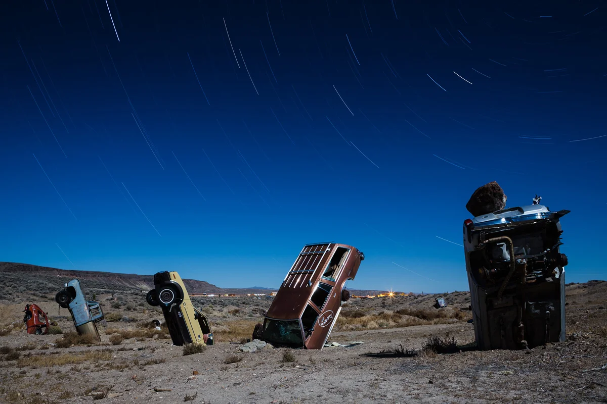 A row of cars under star trails at the International Car Forest - by Joe Reifer