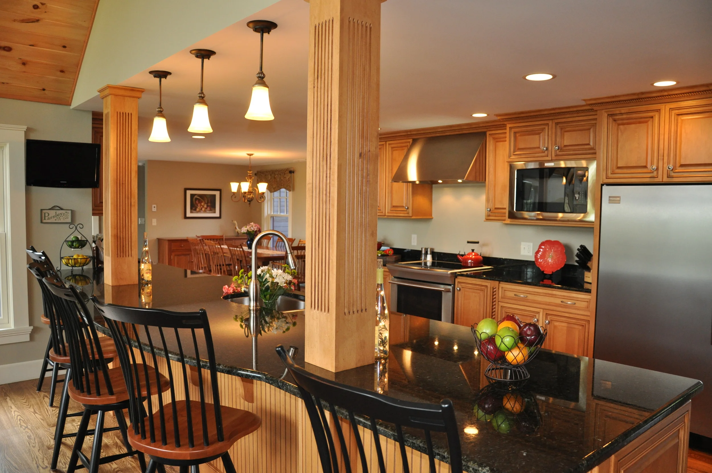 A complete redesigned kitchen featuring maple cabinetry and black granite countertop