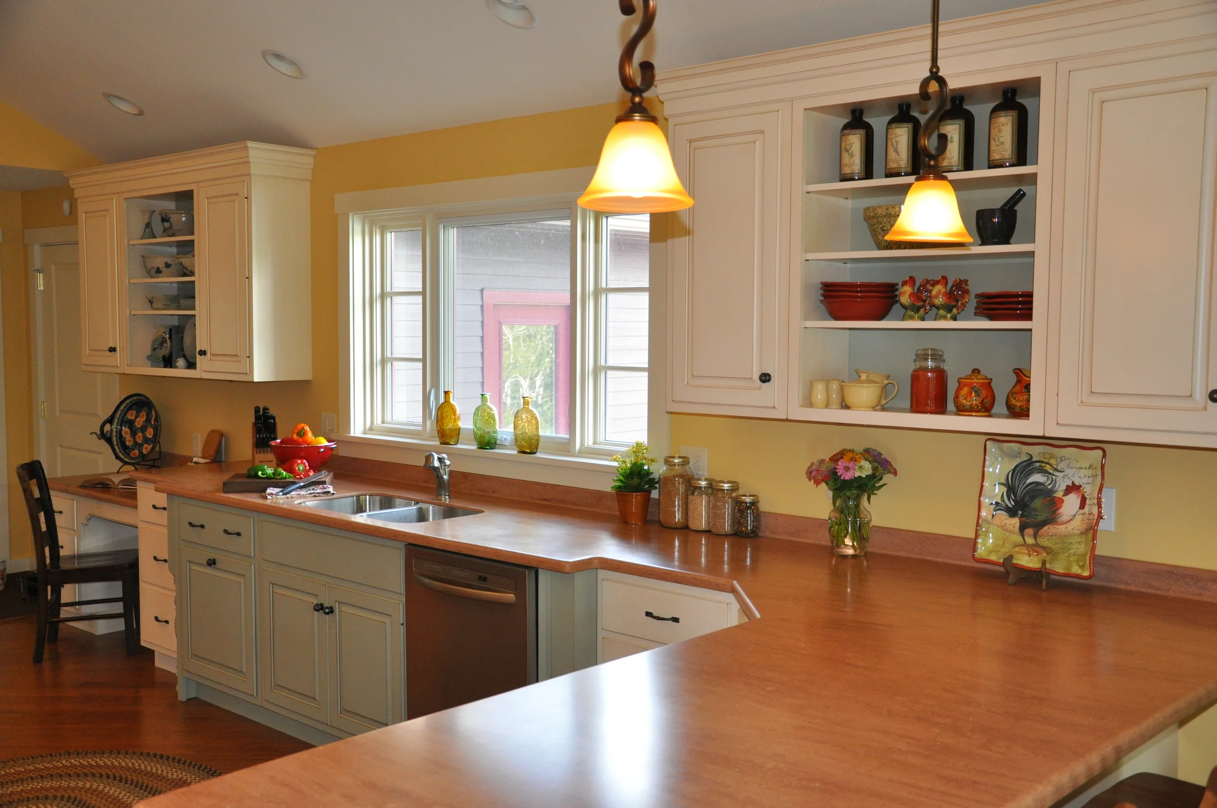 A bright kitchen featuring a L bend walnut countertop and white cabinetry