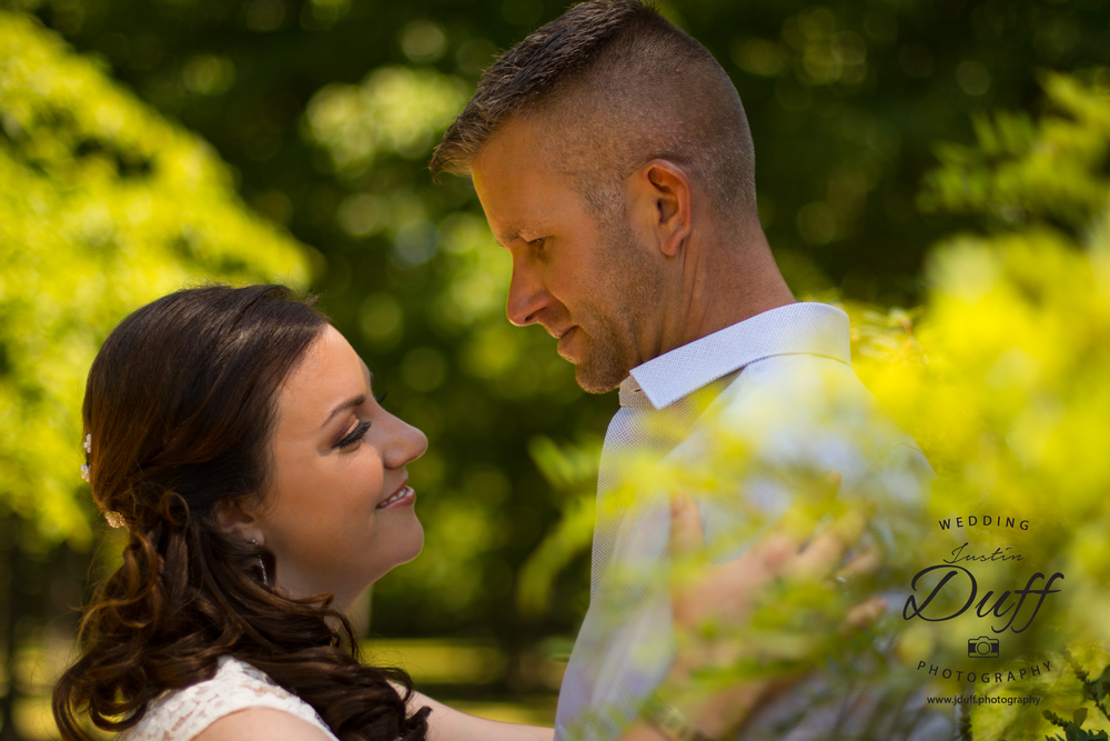  Firefighter Park Wedding - Troy MI wedding photographer. Voyeur behind tree bride and groom smiling. 