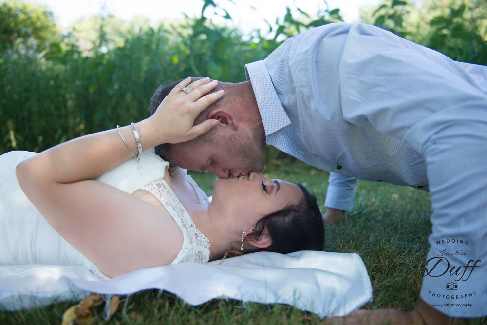  Firefighter Park Wedding - Troy MI wedding photographer. Bride laying on grass. push-up kiss. spider man kiss. 