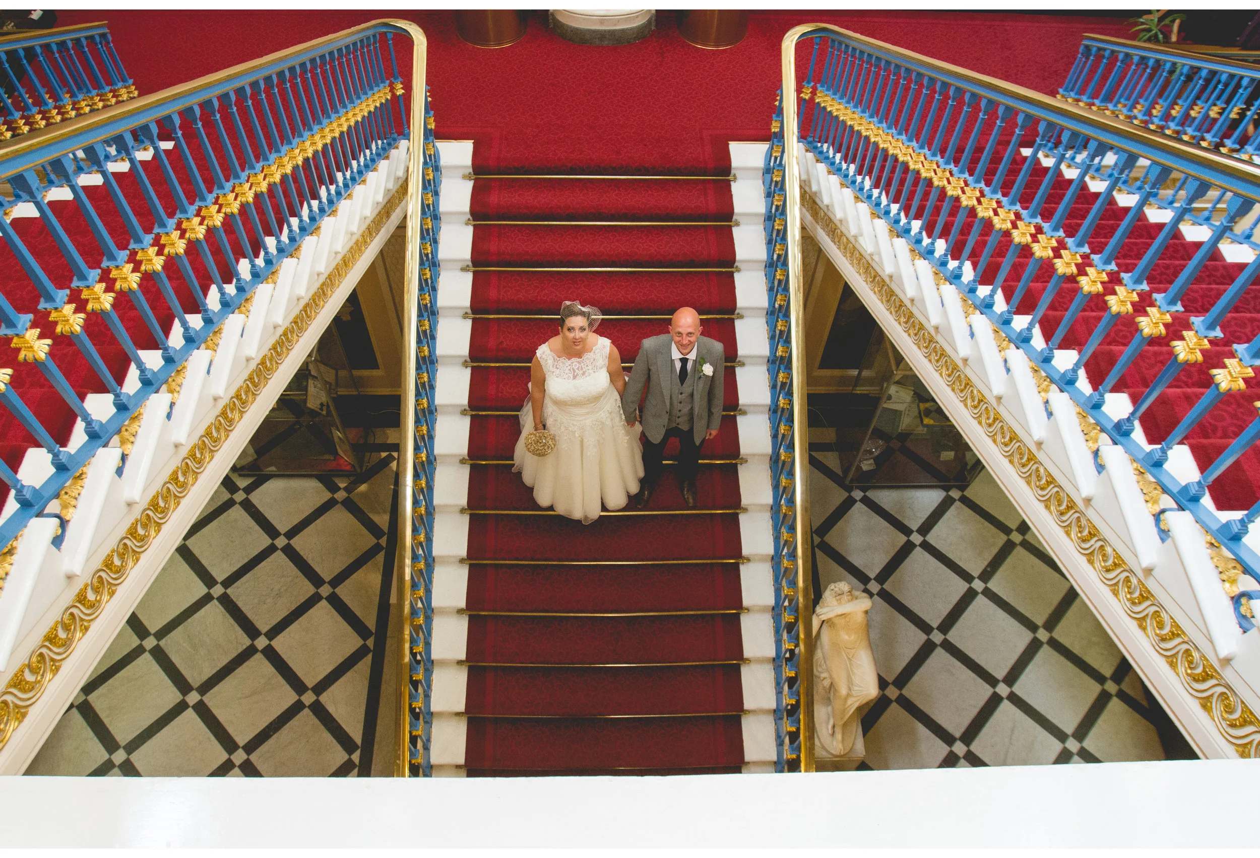 Liverpool Wedding Photography: Bride and Groom on Town Hall Stairs with Red, White, and Blue British flag Vibes