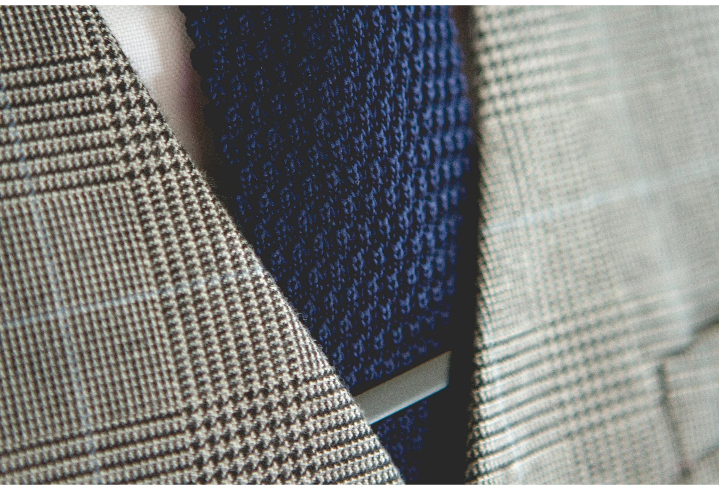 close detail of threads on wedding tie and waist coat 