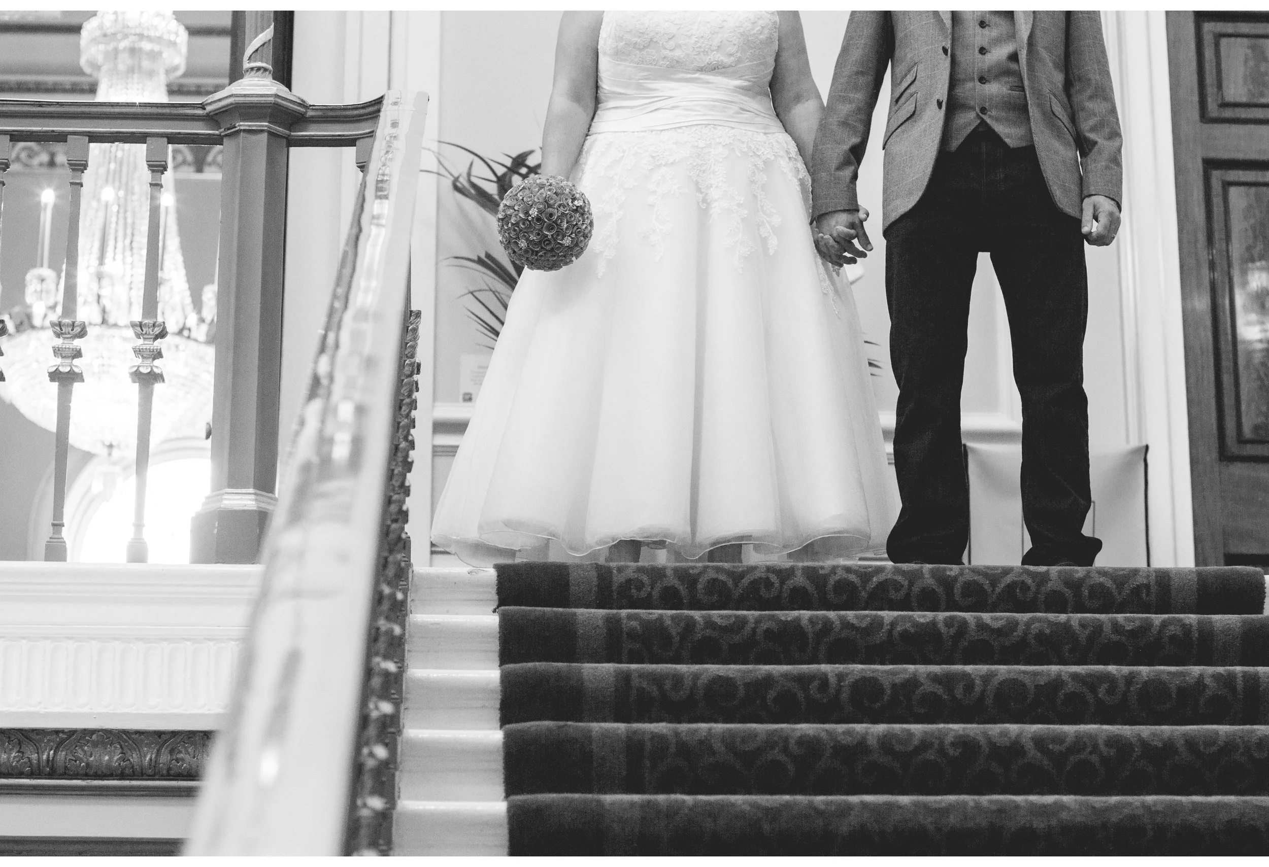 bride and groom holding hands on town hall stairs 
