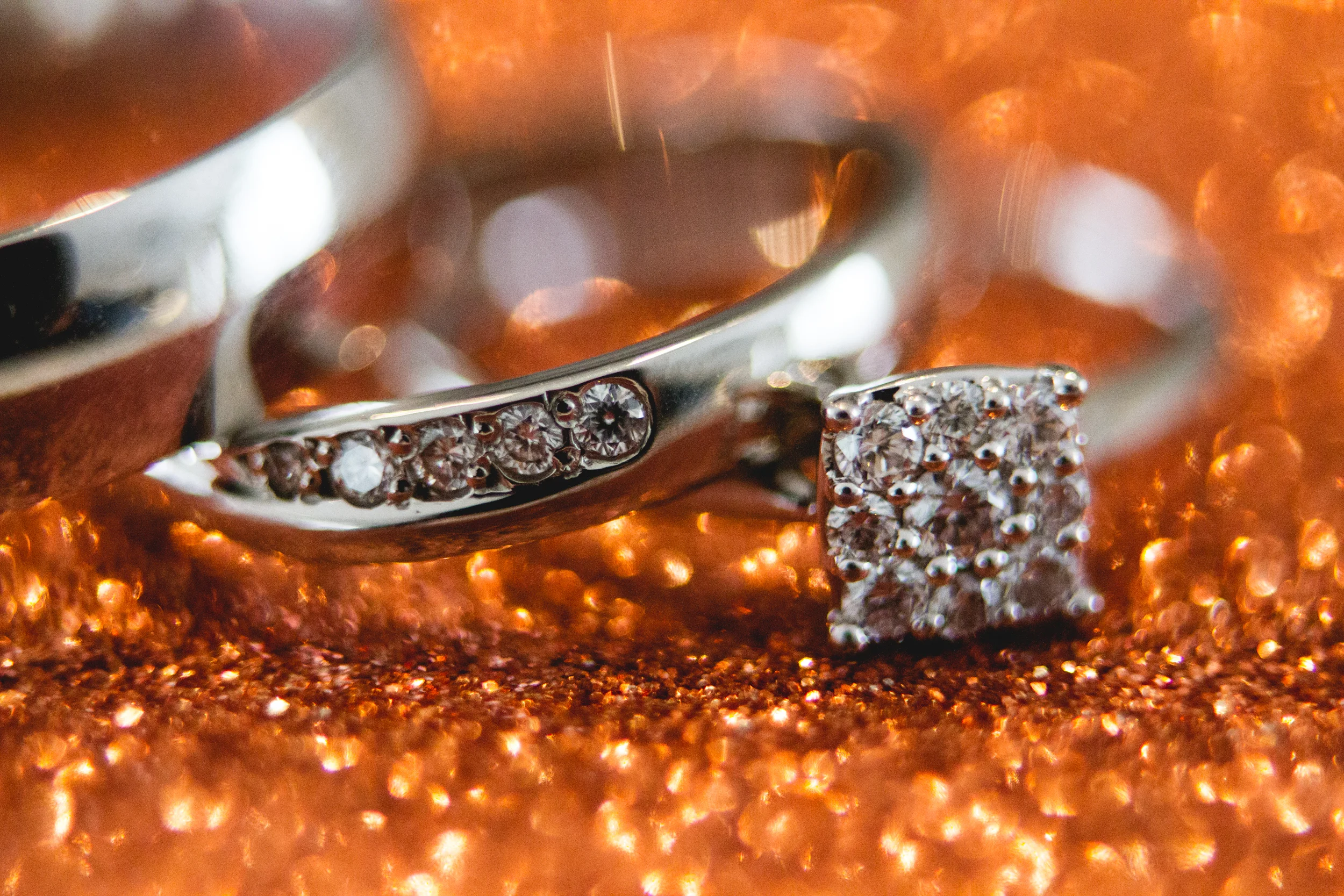 Macro Shot of Wedding Rings Resting on Sparkly Fabric, Capturing the Allure of Every Glittering Aspect.