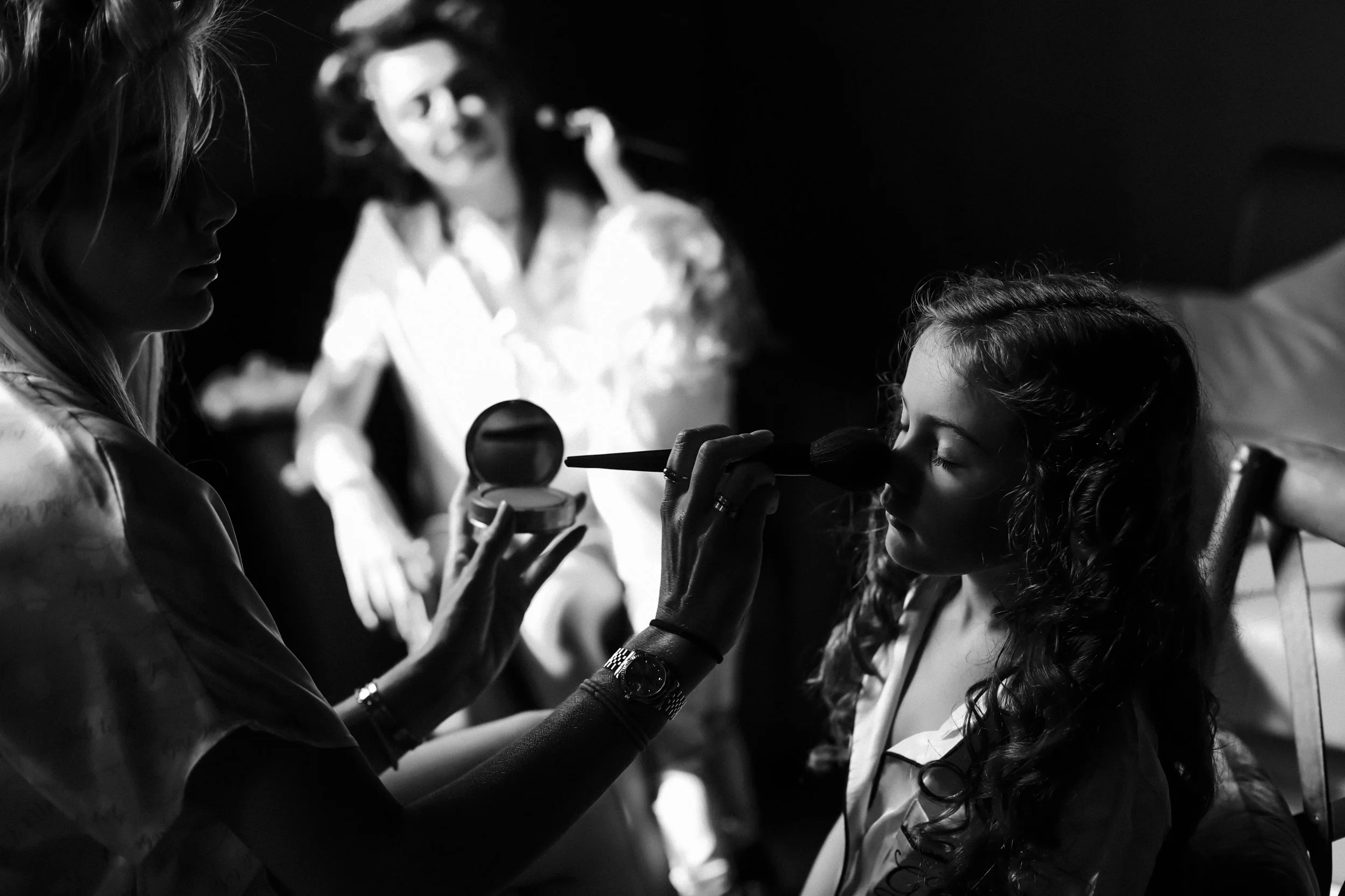 Adorable Moments: Bridesmaid Applies Makeup to the Bride's Young Daughter, Dressed in Wedding-Themed Pyjamas, Creating a Sweet and Cherished Scene