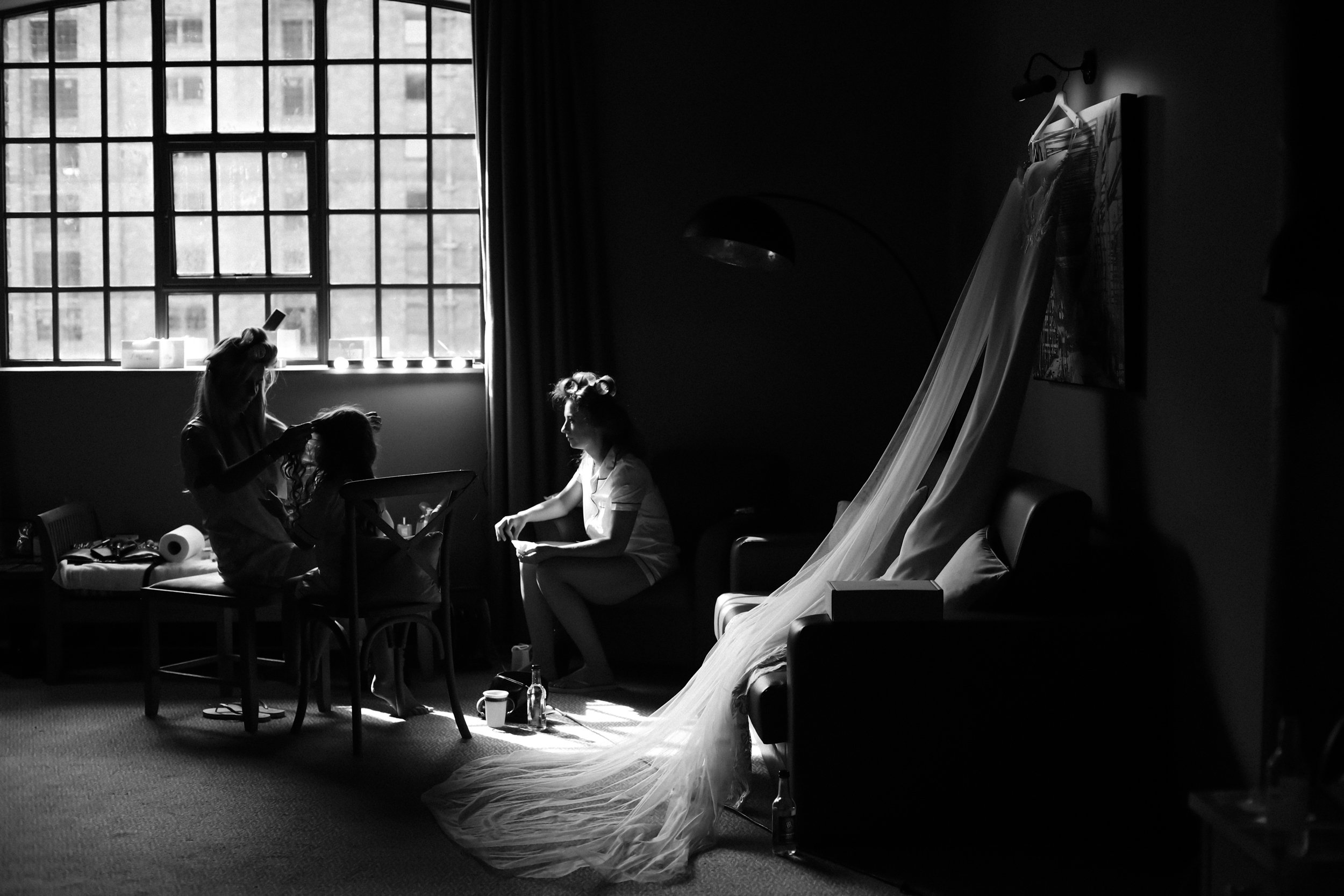 Dramatic Glow: Bride Illuminated by the Light Streaming in from the Window at Titanic Hotel, Creating a Captivating and Mysterious Atmosphere.
