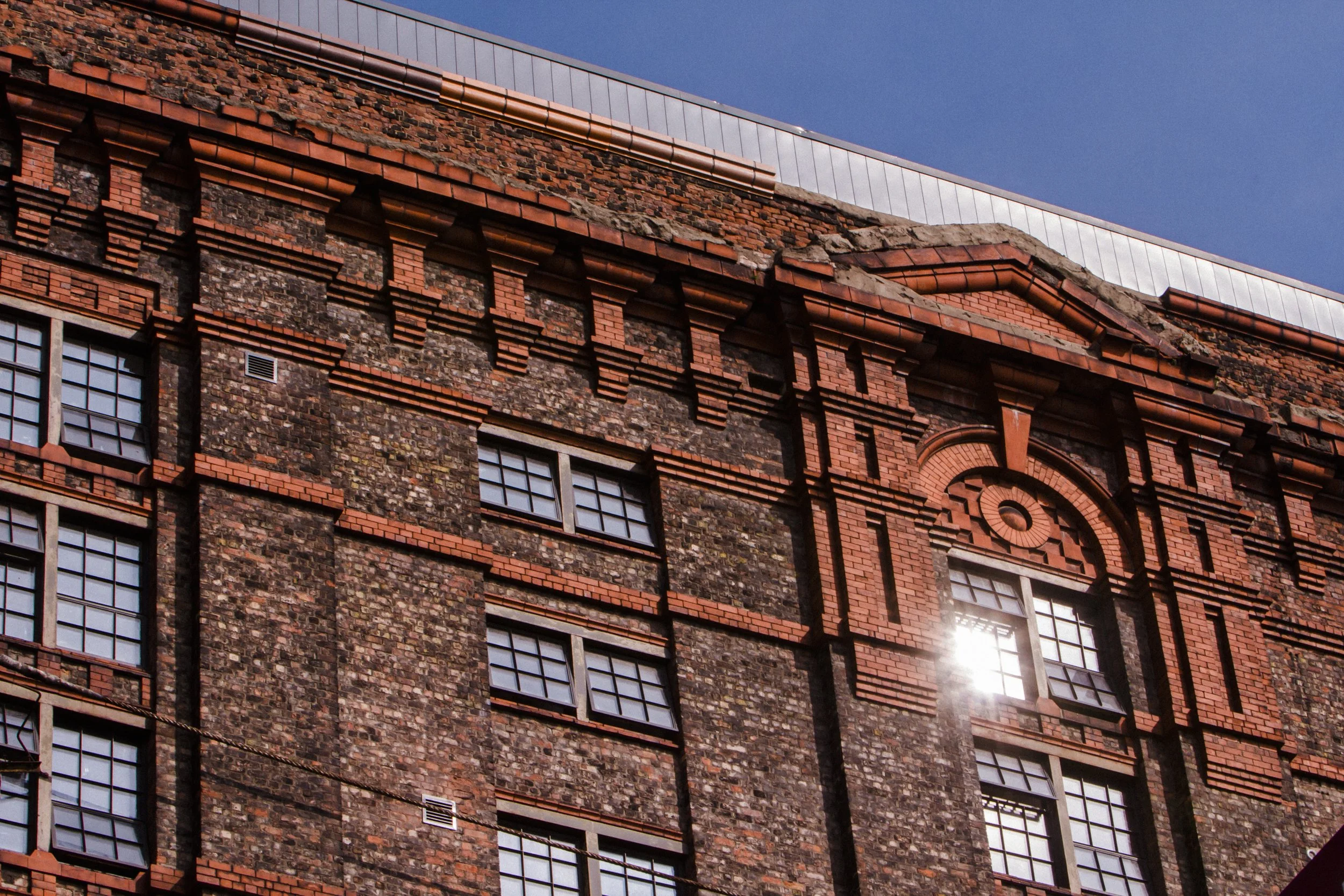 Historic Glow: Sunlight Casts a Warm Embrace on the Old Buildings Opposite Titanic Hotel, Infusing the Scene with a Nostalgic Charm.