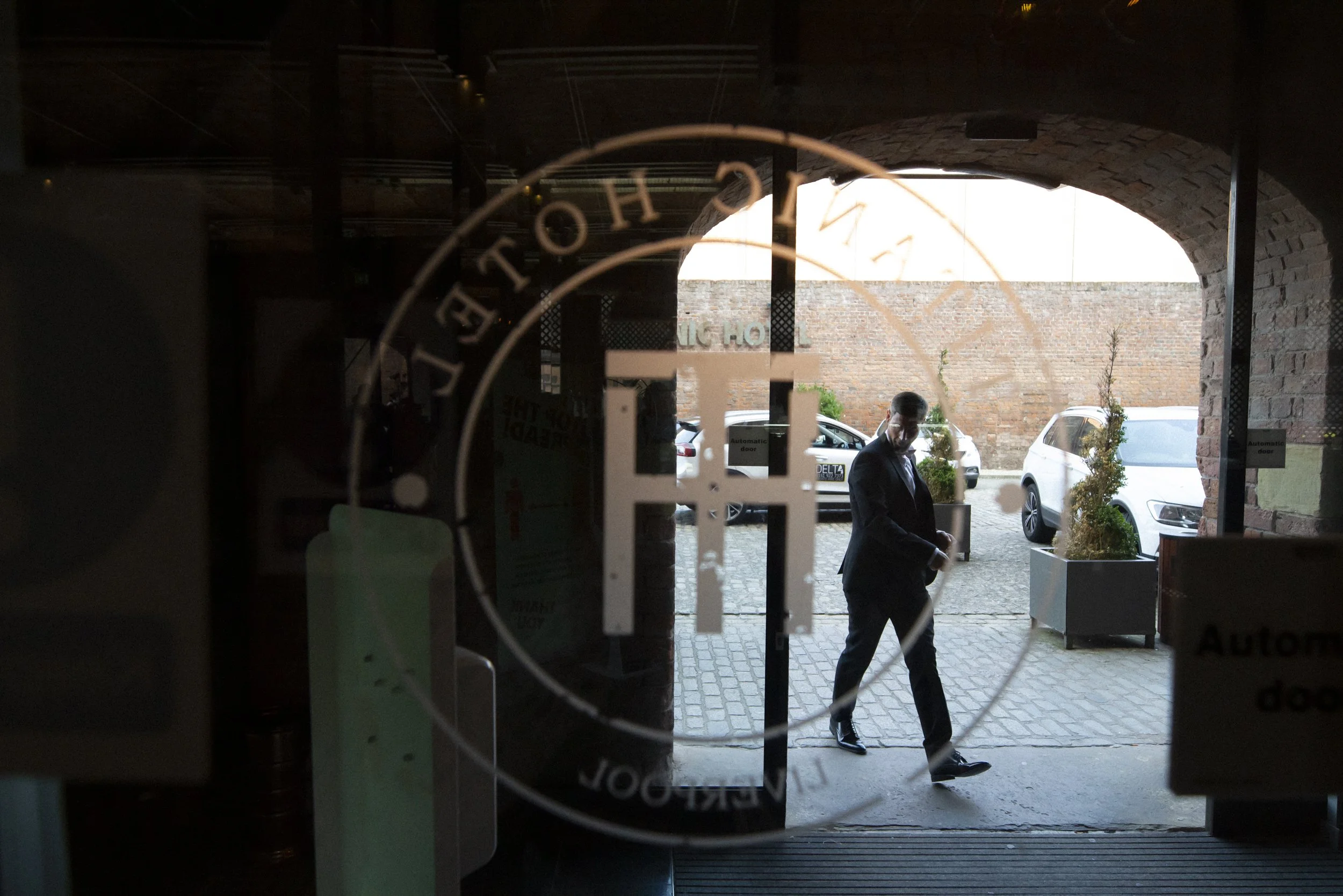 Swift Arrival: Groom Enters the Titanic Hotel with Purpose and Anticipation, Marking the Start of His Memorable Day.