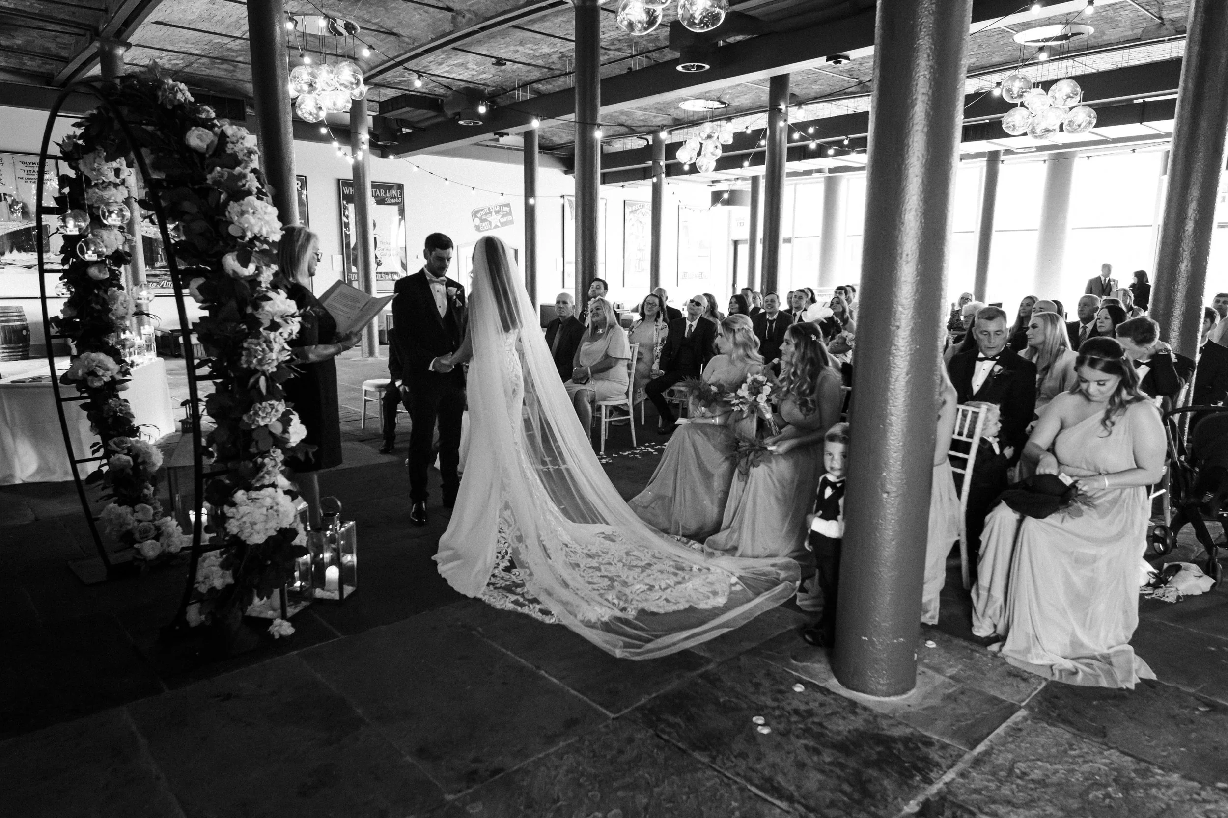 ride and Groom, Surrounded by Their Beloved Guests, Share an Intimate Ceremony at Titanic Hotel, Embracing the Love and Support of Their Family and Friends.