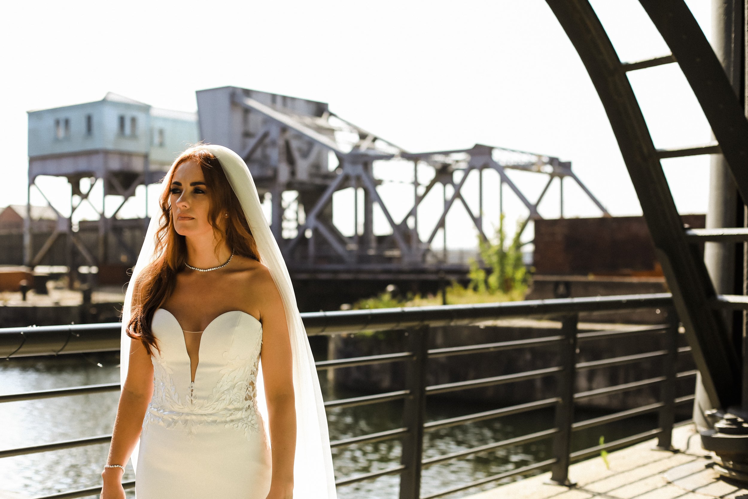 Radiant Vision: Bride Looks Ahead, Bathed in the Sun's Warm Glow at Titanic Hotel Liverpool, Radiating Elegance and Poise on Her Special Day.