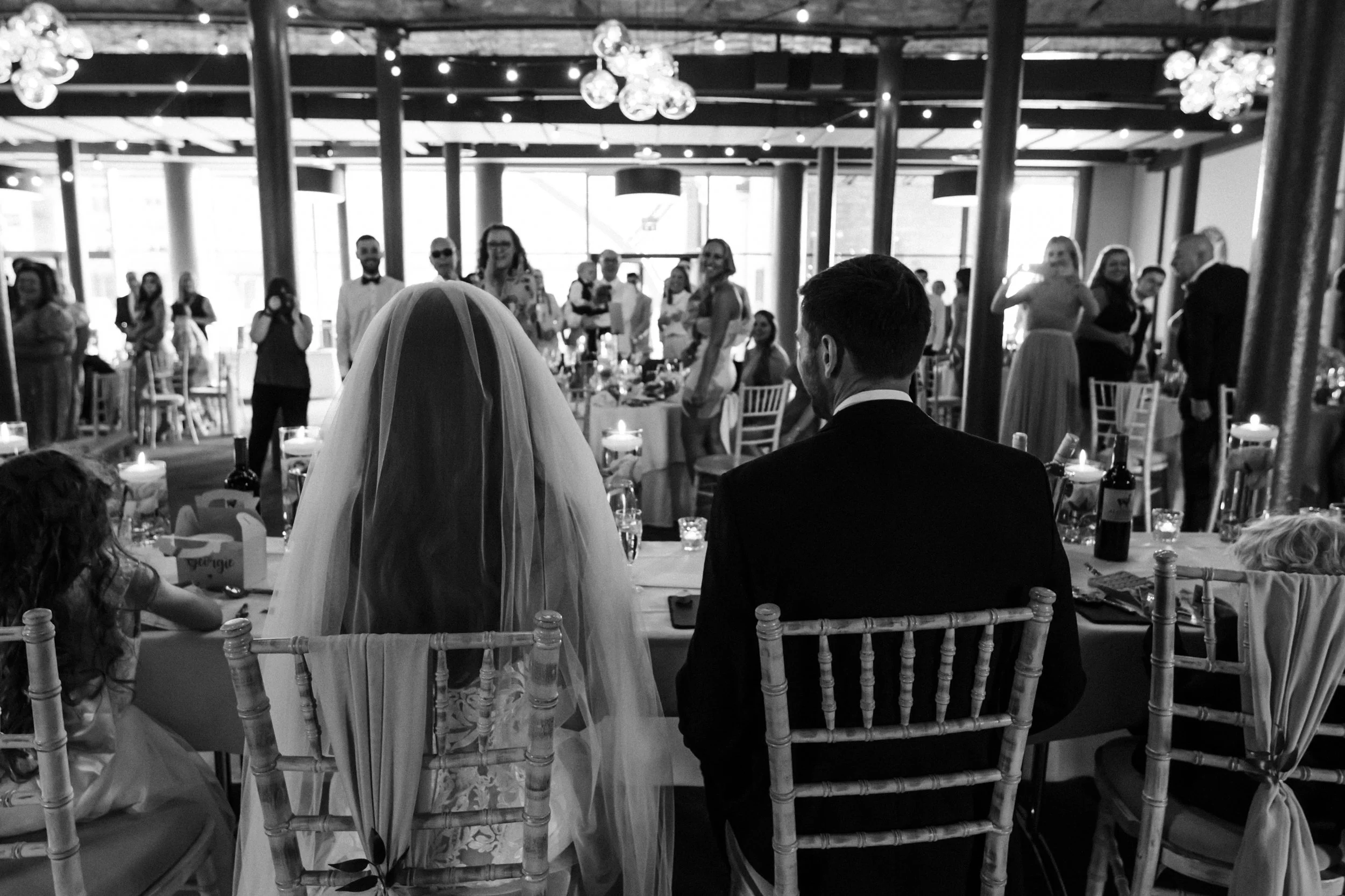  A View of the Wedding Breakfast from Behind the Bride and Groom at Titanic Hotel Liverpool, Capturing the Atmosphere of the Joyous Feast.