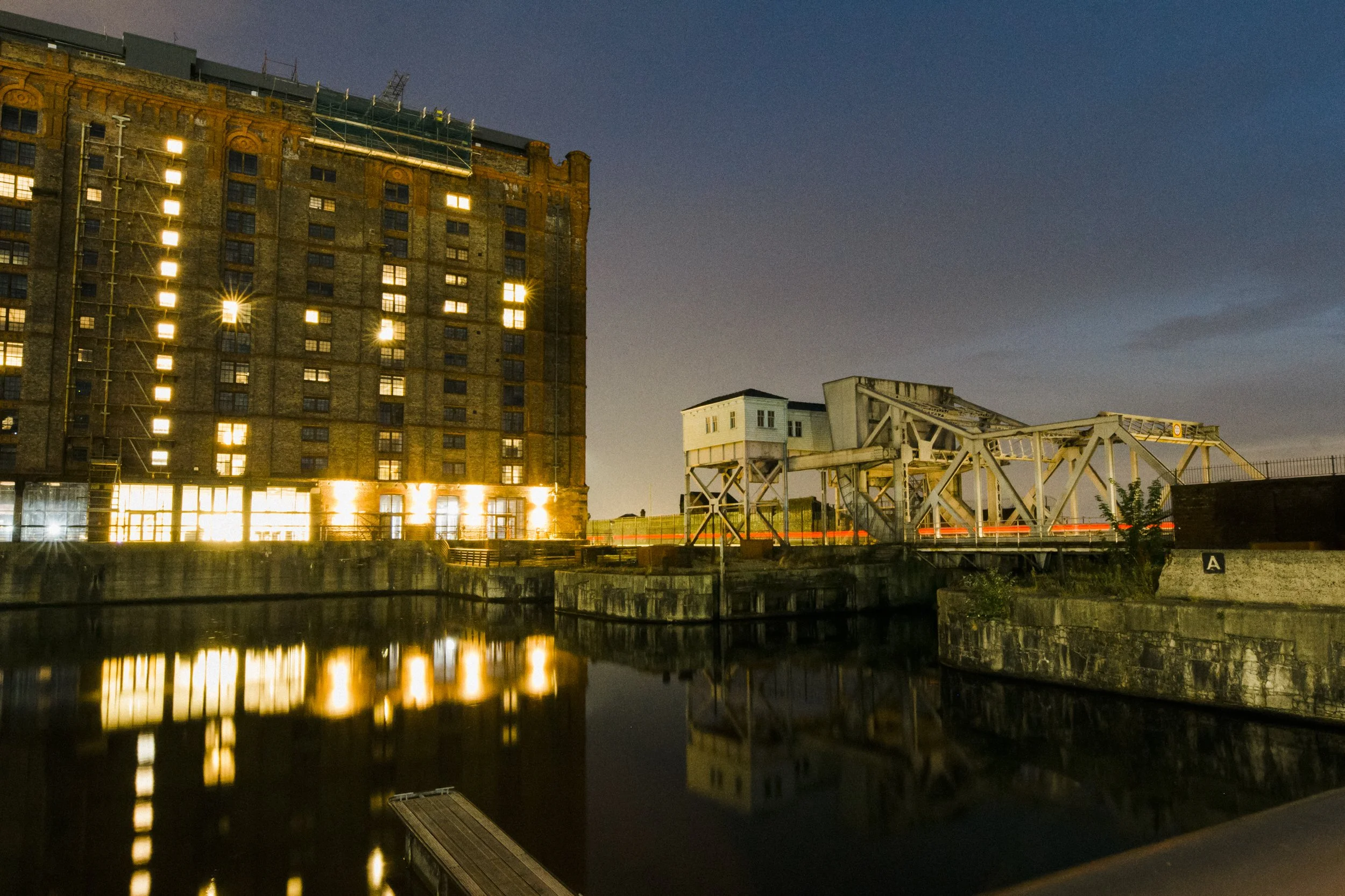 The Atmosphere of Stanley Dock at Night During a Titanic Hotel Liverpool Wedding, Glistening with Lights and Creating a Magical Setting for the Celebrations.