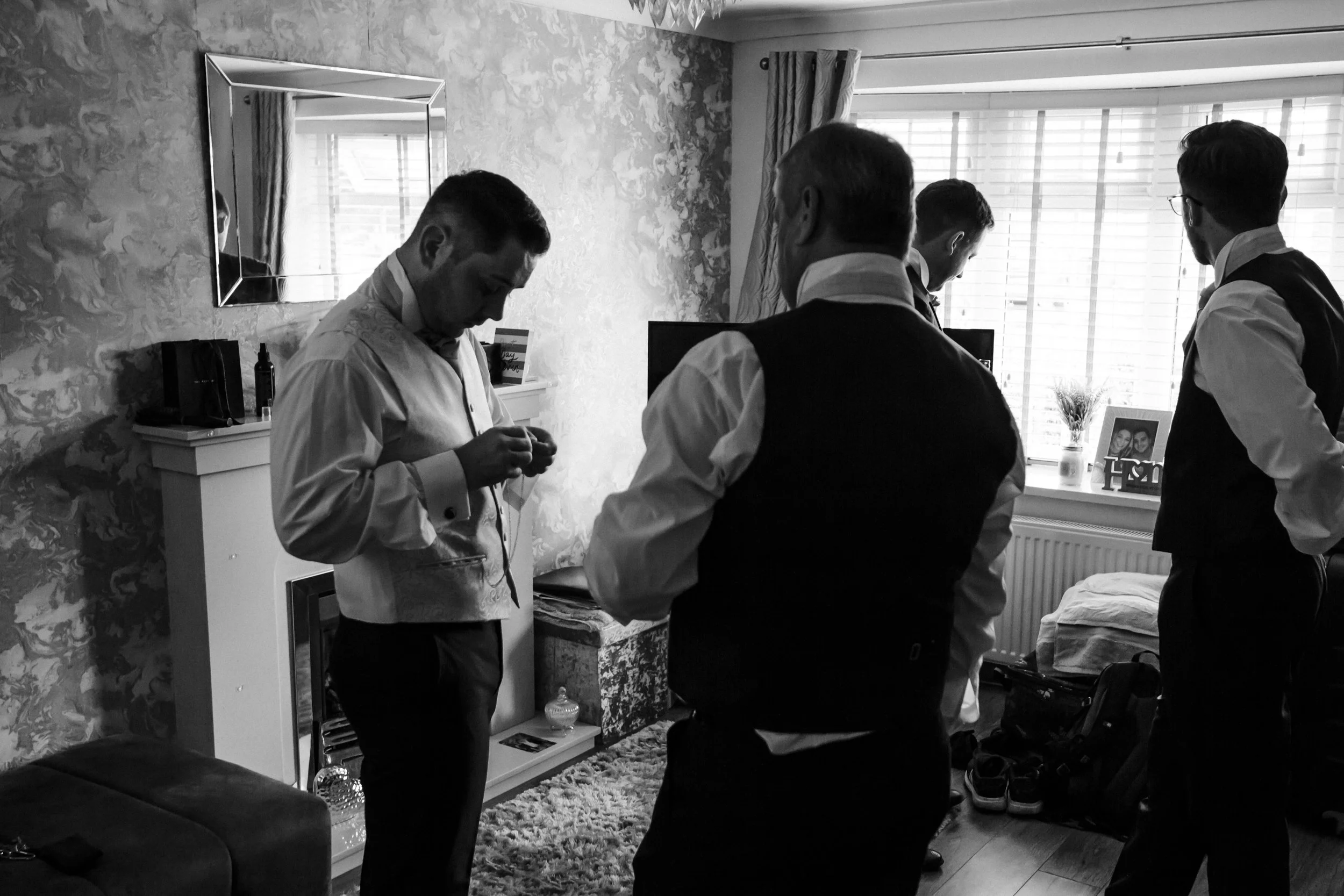 Groom and Groomsmen Prep: A Candid Moment Capturing the Groom and His Groomsmen Getting Ready on the Morning of the Wedding Day, Creating a Sense of Camaraderie and Excitement.