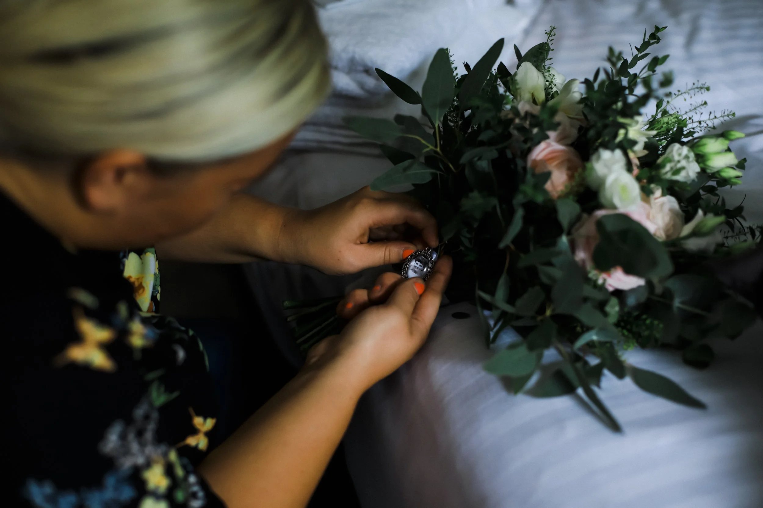In Loving Memory: A Touching Tribute to a Loved One with a Photo on the Bride's Bouquet, Preserving Their Memory and Presence on a Special Day at Brook Hall Hotel.