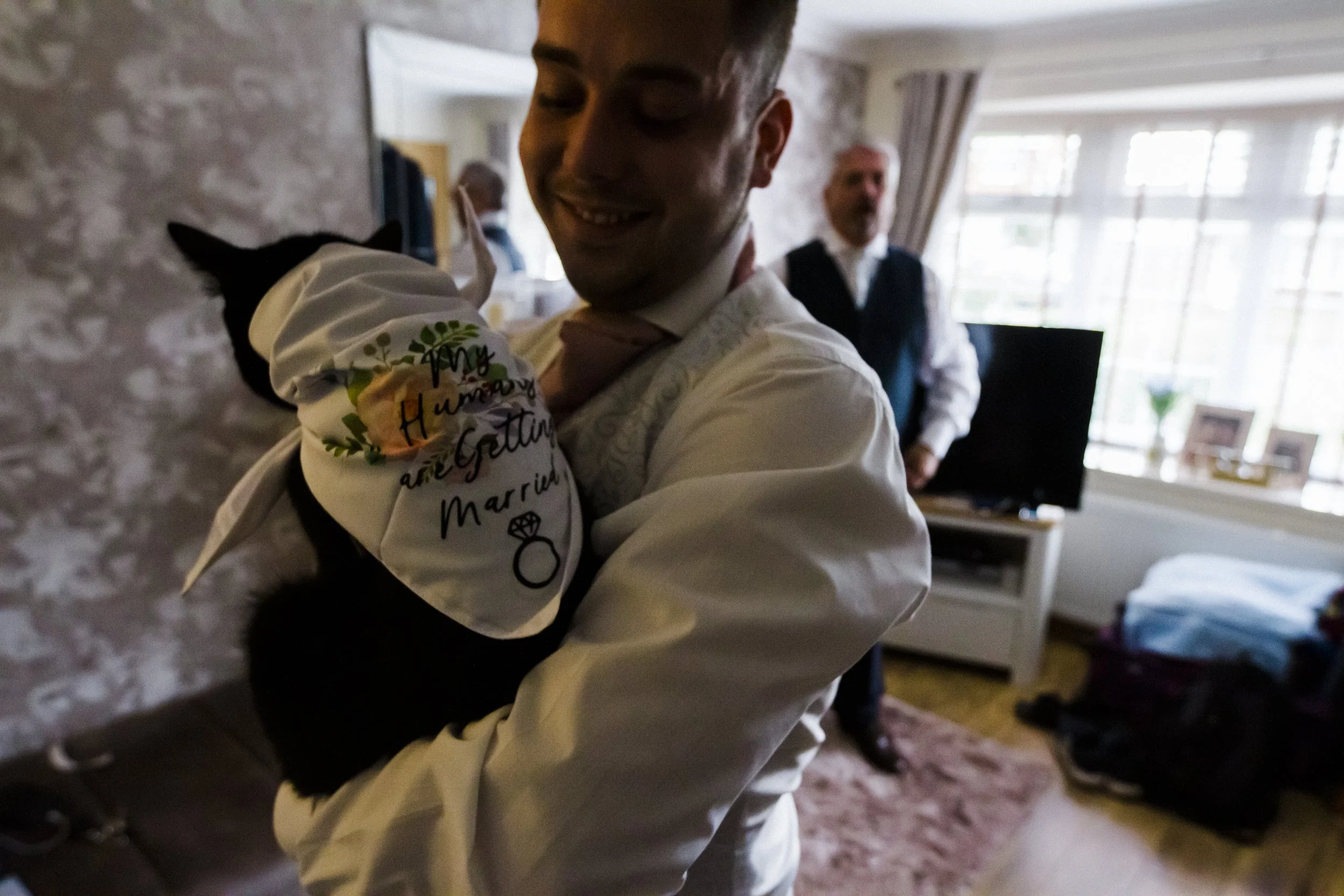 Furry Companion: The Groom Holds His Cat, Dressed in a Wedding Outfit, Creating a Heartwarming and Memorable Moment Captured by the Brook Hall Wedding Photography 