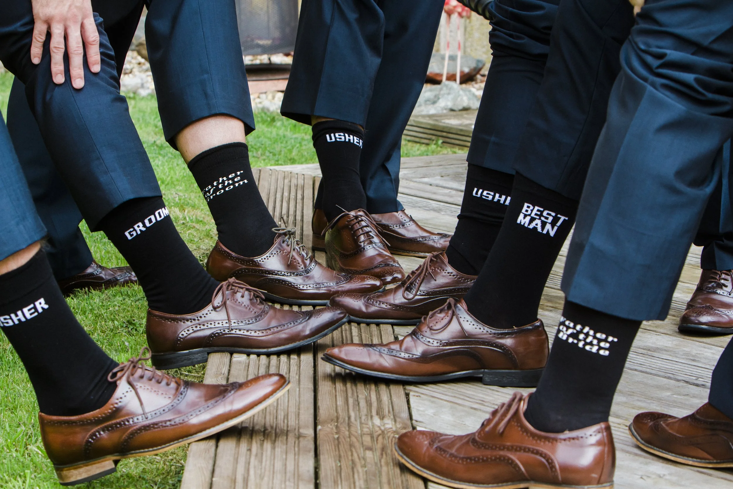 Sock Game: The Groom and His Groomsmen Show Off Their Stylish and Coordinated Socks, Adding a Fun and Fashionable Touch to the Wedding Attire. Brook Hall Hotel wedding photography 