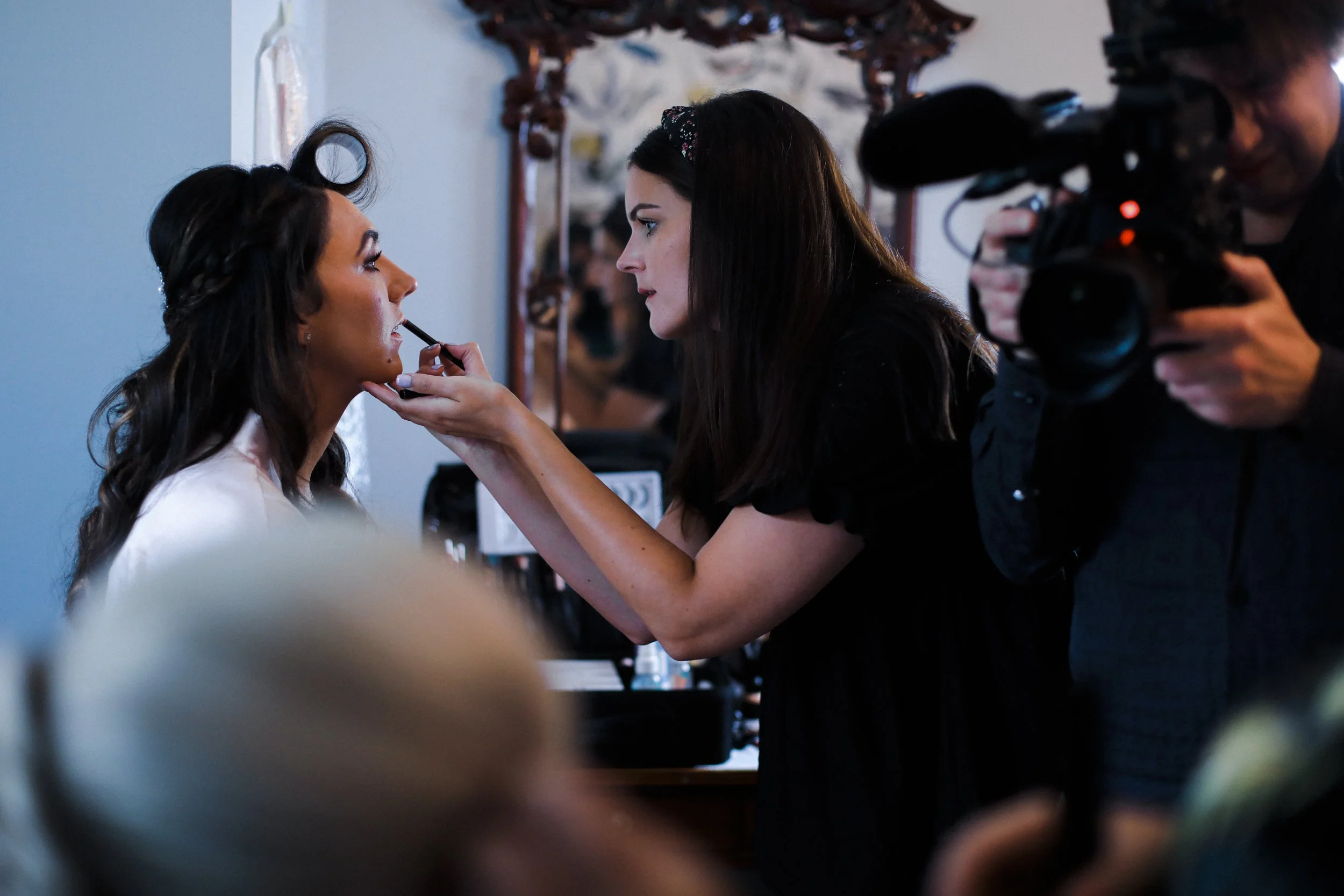 Finishing Touch: A Bridesmaid Gets Lipstick Applied, Adding a Final Touch of Glamour and Beauty, Captured with Precision by the Brook Hall Wedding Photographer.