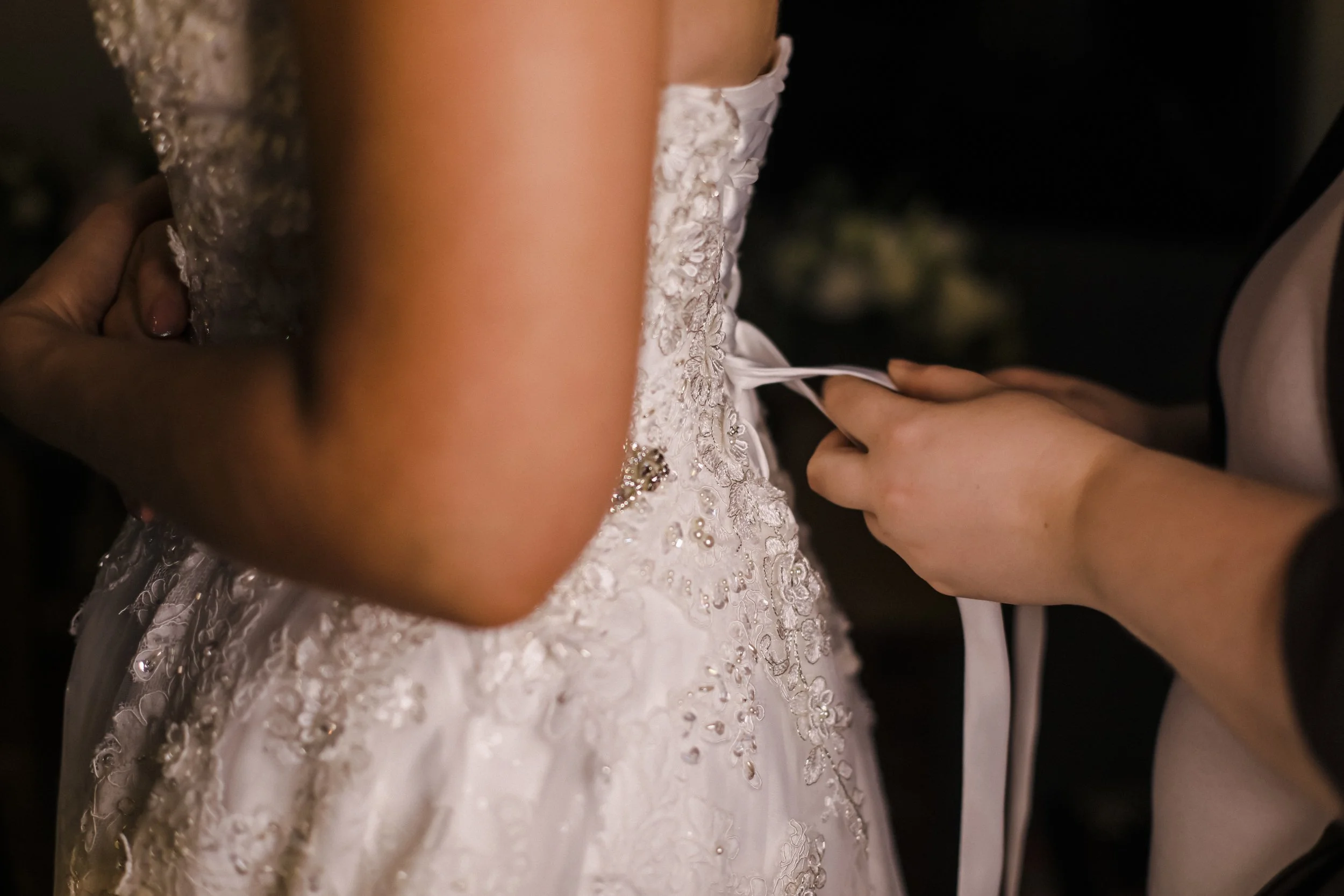 Elegant Moments: The Bride Gets Her Dress Tied, Ensuring Every Detail Is Perfectly in Place for Her Special Day. Brook Hall Hotel Wedding