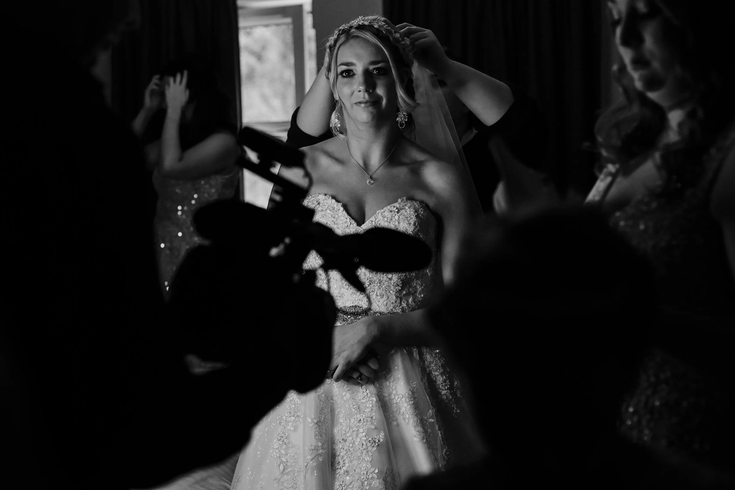 The Bride Receives Final Touches to Her Dress and Hair, Creating a Picture of Grace and Beauty at Brook Hall. 