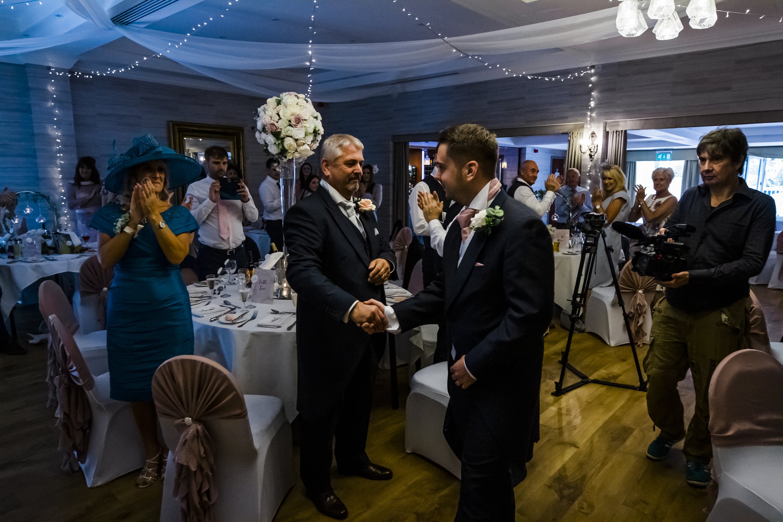 father of the groom shaking hands with groom Brook Hall hotel wedding photography