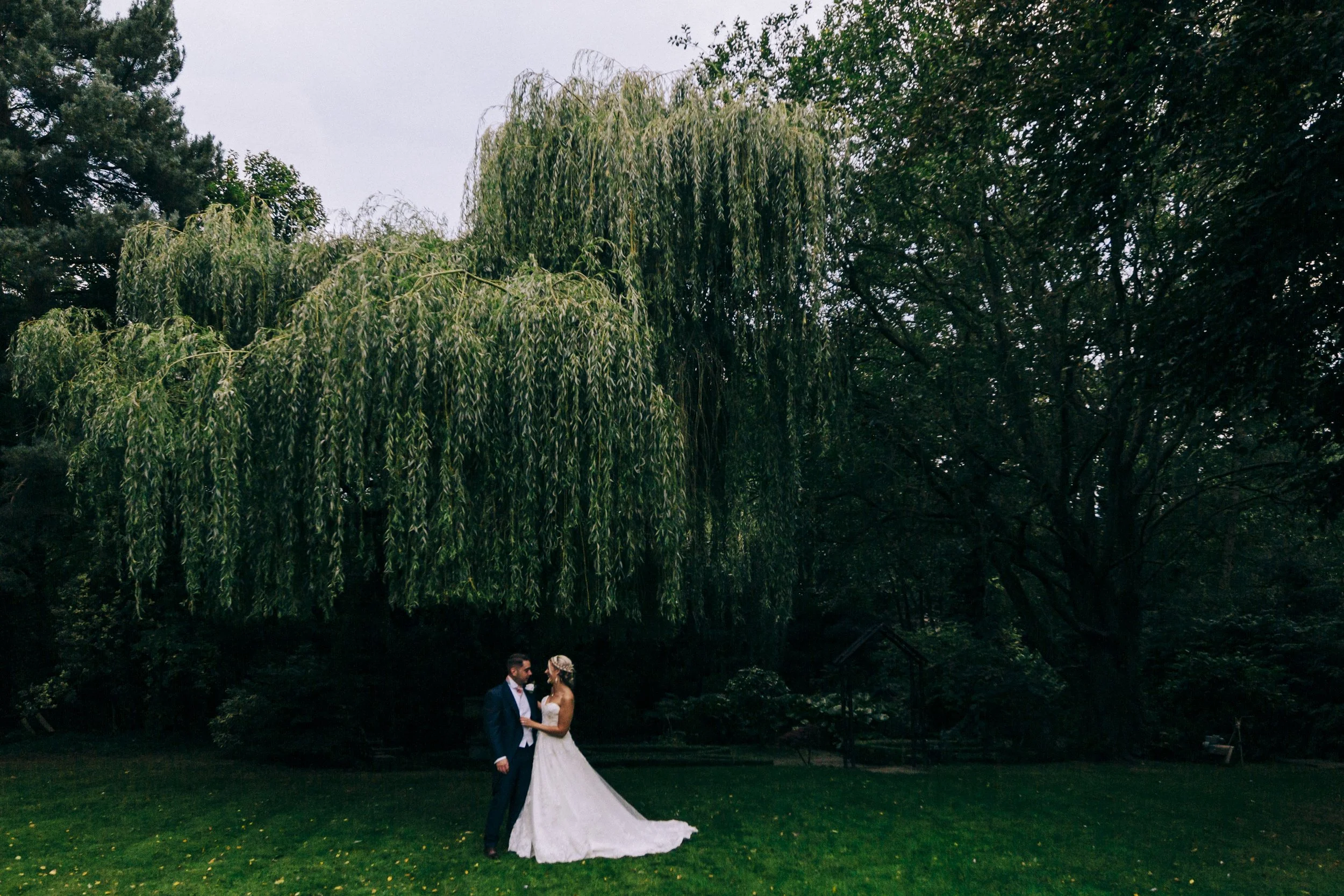 Bride and Groom Embrace Underneath the Graceful Willow Tree in this Stunning Brook Hall Hotel Wedding Photography