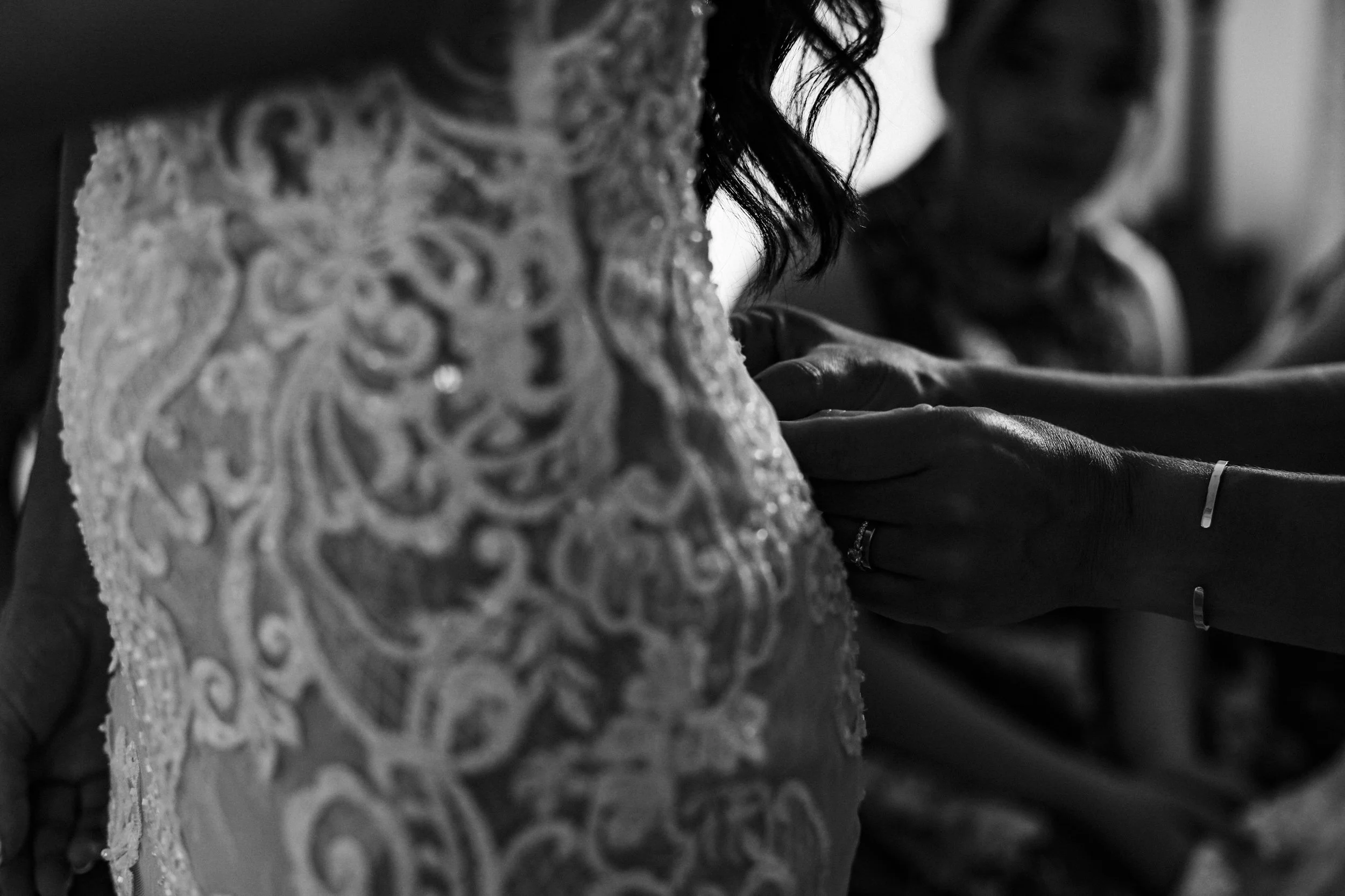 Intricate Details: A Close-Up Captures the Beautiful Laces of the Bride's Dress as Her Bridesmaids Carefully Fasten It, Creating a Memorable Moment for the Albert's Standish Wedding.